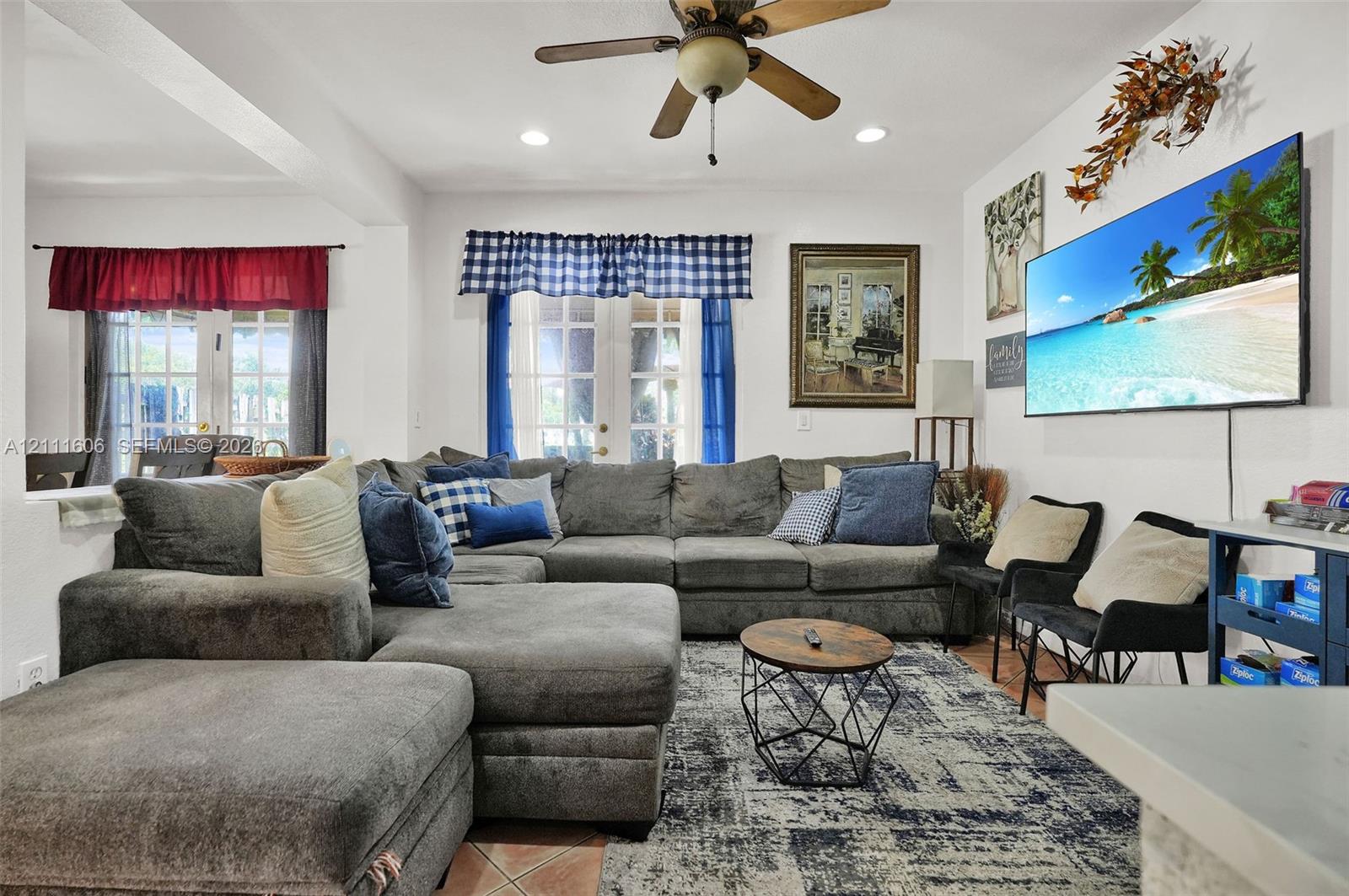 Living area featuring tile flooring, ceiling fan, recessed lighting, and dual sets of French doors Living area featuring tile flooring, ceiling fan, recessed lighting, and dual sets of French doors