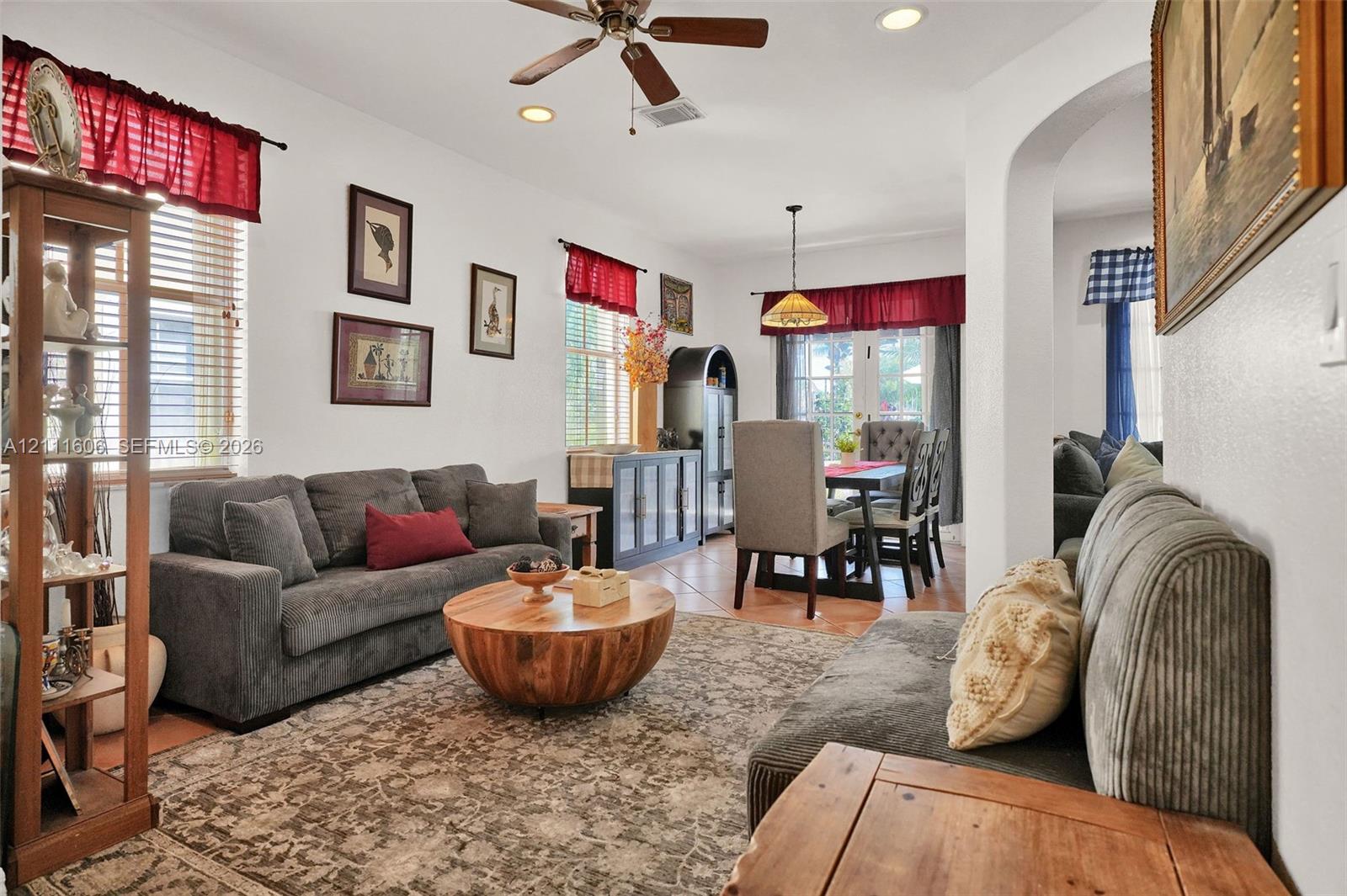 Open-concept interior featuring recessed lighting, a ceiling fan, arched doorways, and tile flooring Open-concept interior featuring recessed lighting, a ceiling fan, arched doorways, and tile flooring