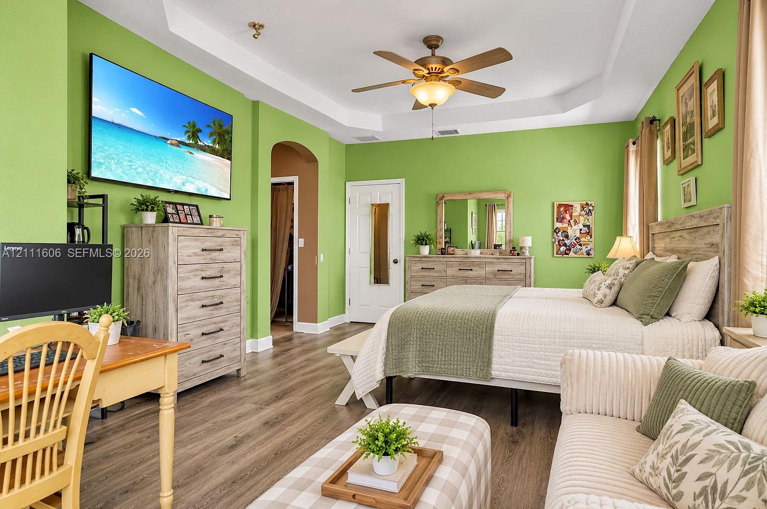 Tray ceiling with a central multi-blade ceiling fan and wood-finish flooring Tray ceiling with a central multi-blade ceiling fan and wood-finish flooring