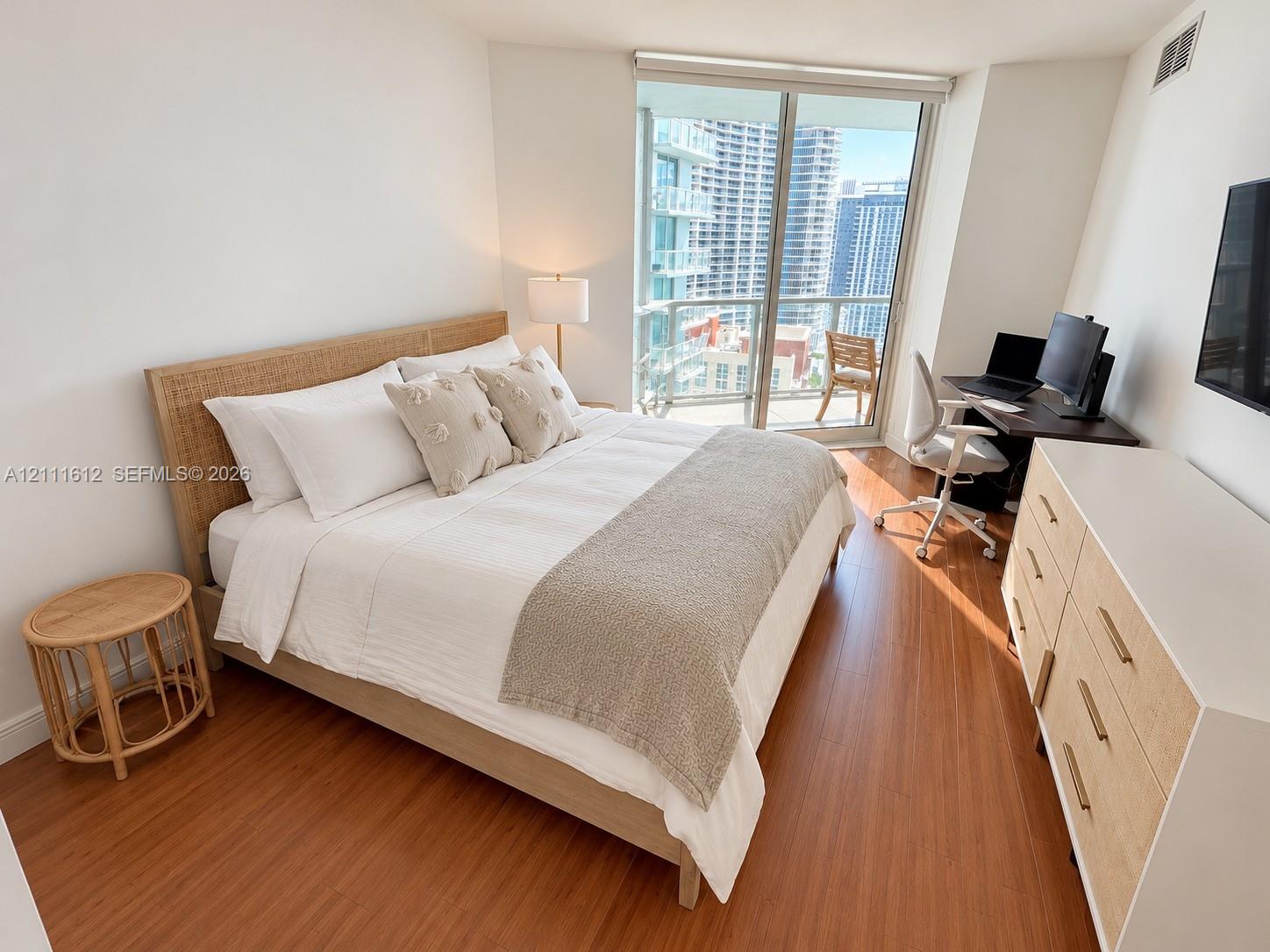 Wood-finish flooring, floor-to-ceiling glass sliding door, and private balcony