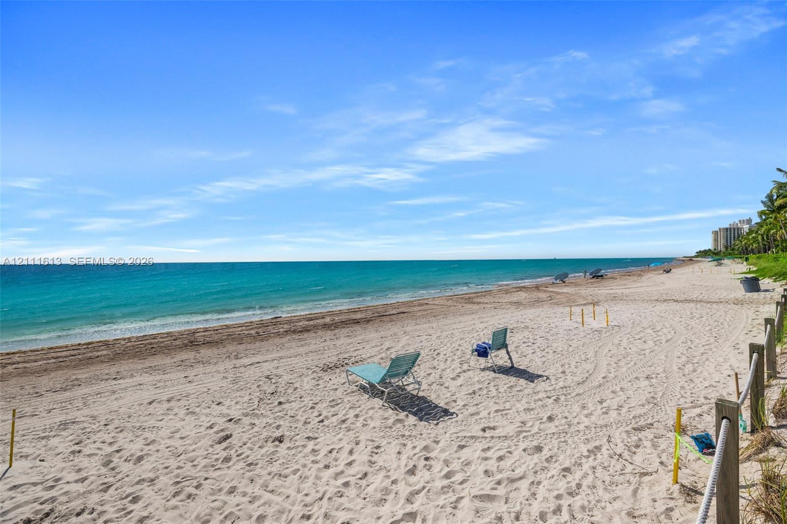 Sandy beachfront property featuring a perimeter wood post and rope boundary fence