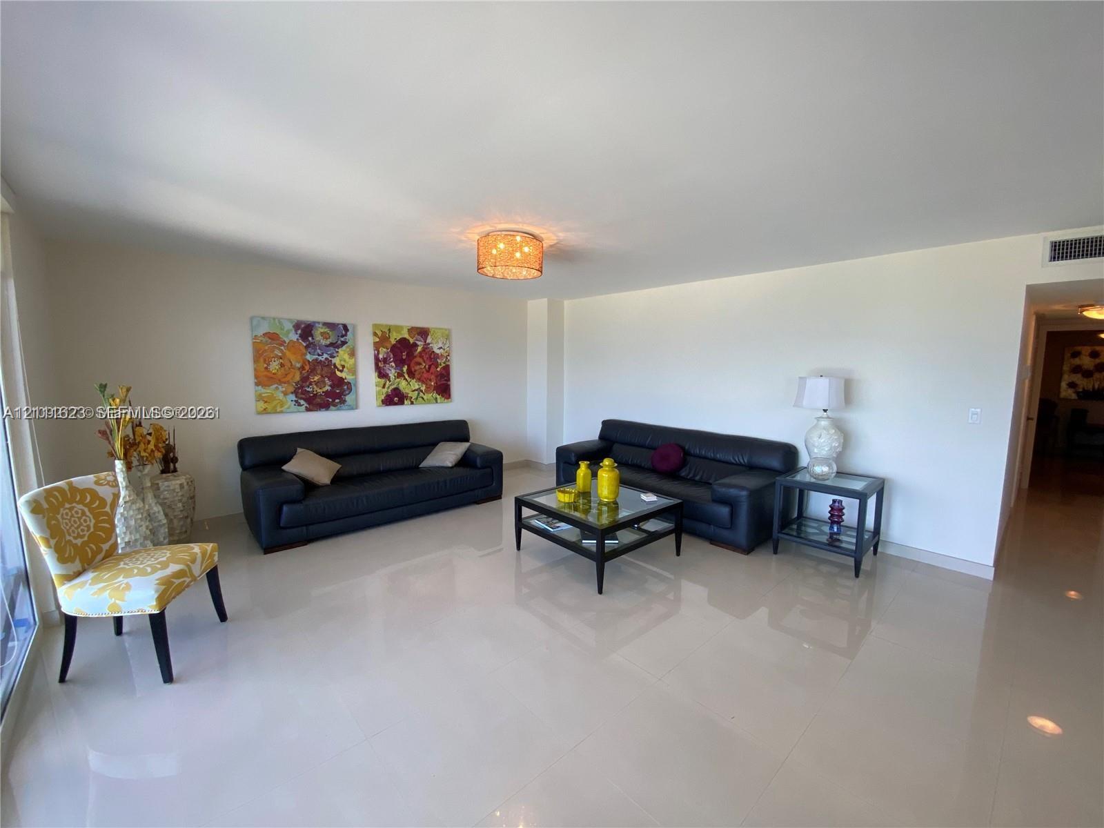 Living area featuring polished stone flooring and a decorative flush-mount ceiling light fixture