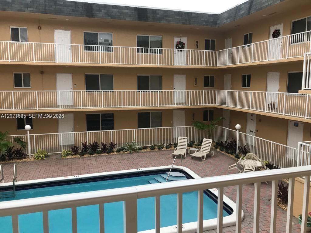 Multi-level exterior featuring white railings, integrated swimming pool, and paver-stone courtyard