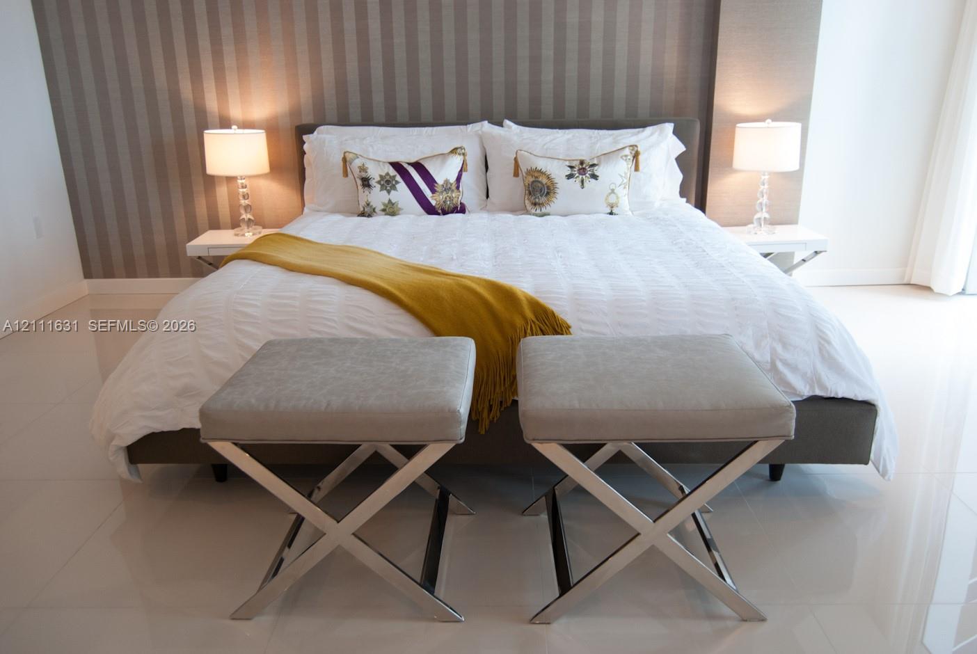 Neutral-toned striped wallpaper, large-format tile flooring, and two wall-mounted floating shelves