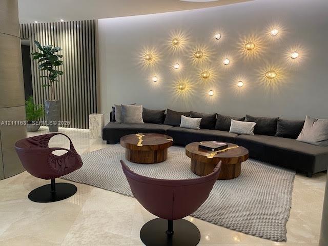 Polished stone flooring, textured wood-slat wall paneling, and custom circular wall-mounted lighting fixtures Polished stone flooring, textured wood-slat wall paneling, and custom circular wall-mounted lighting fixtures