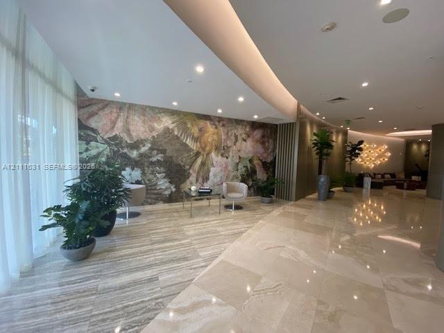 Polished stone flooring, floor-to-ceiling sheer window treatments, decorative feature wall with floral mural, and recessed lighting Polished stone flooring, floor-to-ceiling sheer window treatments, decorative feature wall with floral mural, and recessed lighting