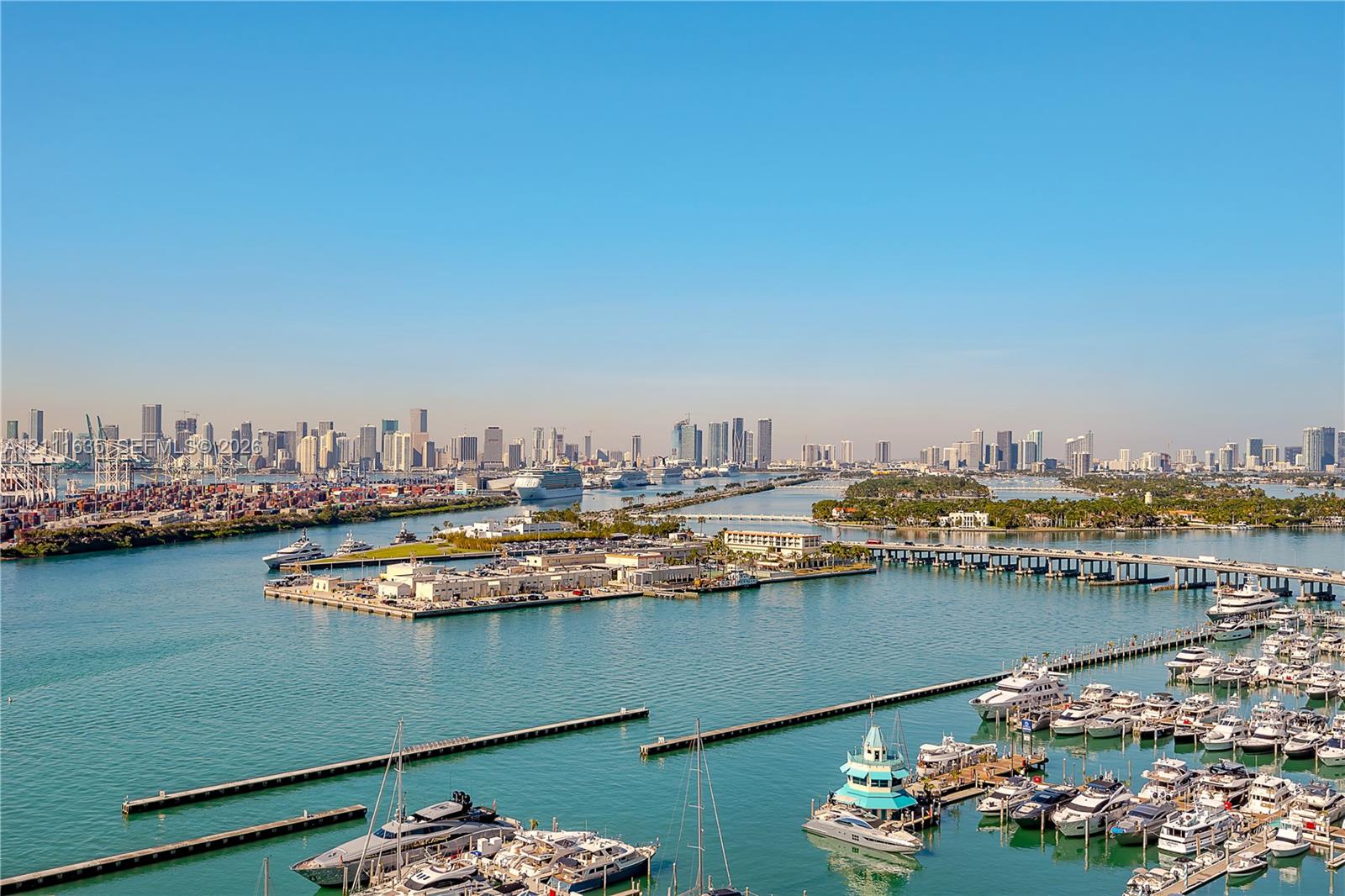 Panoramic perspective of the city skyline, active harbor, and marina featuring multiple boat slips