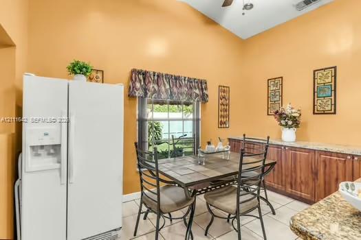 Vaulted ceiling featuring a central light fixture and built-in cabinetry with stone-surface counters and wood-finish doors