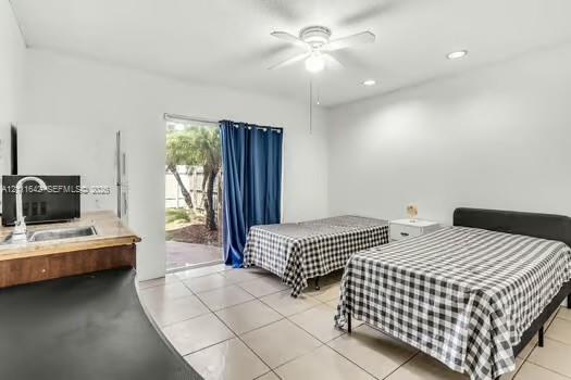Interior featuring ceramic tile flooring, recessed lighting, ceiling fan, and a wet bar with a stainless steel faucet and sink