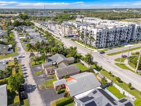 Aerial perspective featuring multi-story residential structures and established palm tree landscaping