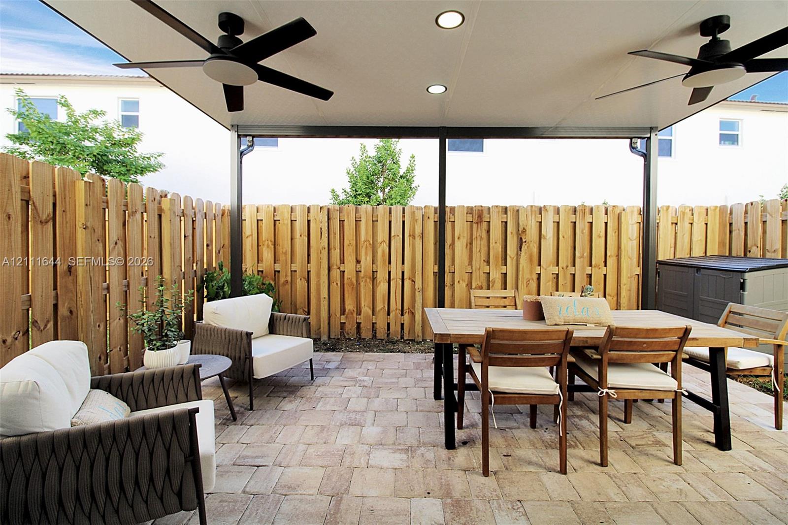 Covered patio featuring a paver surface, recessed lighting, two ceiling fans, and a wood privacy fence