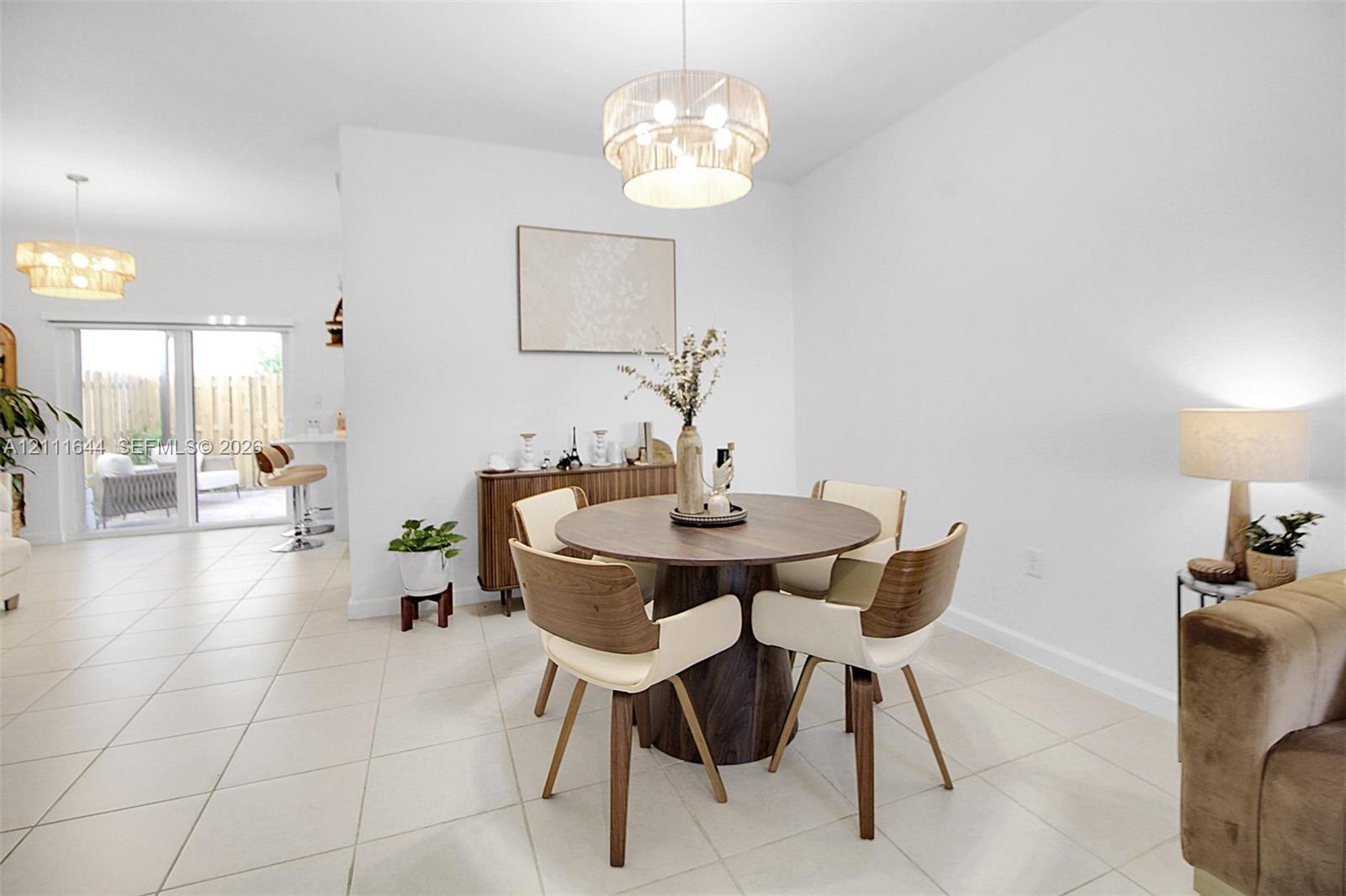 Large-format tile flooring, drum-style pendant lighting, and sliding glass doors