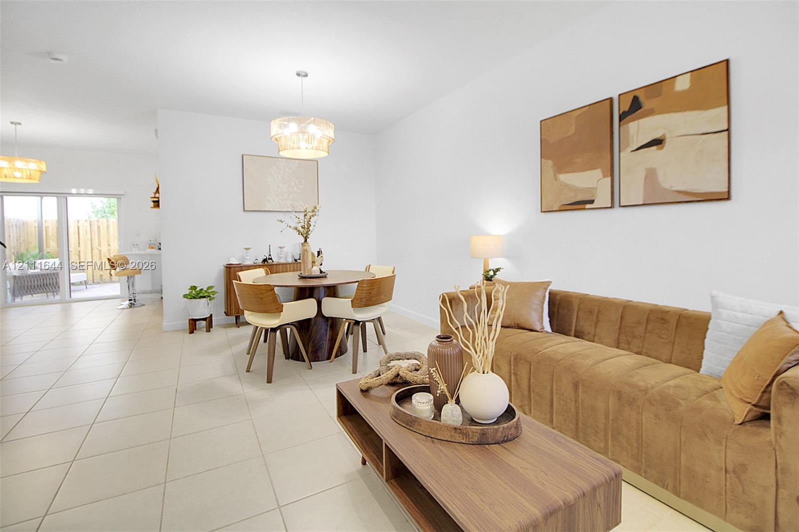 Open-concept interior featuring oversized tile flooring, recessed lighting, decorative tiered pendant fixtures, and a large sliding glass door