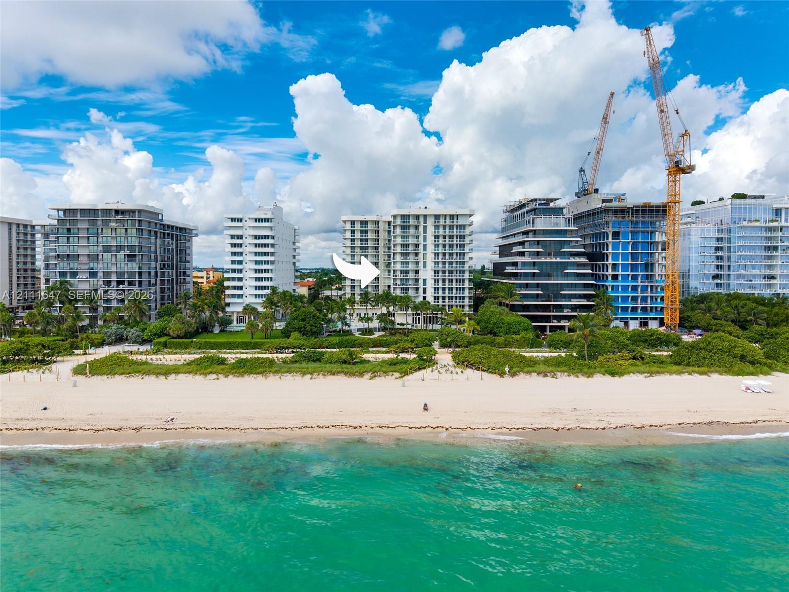 High-rise oceanfront building featuring private balconies, floor-to-ceiling glass windows, and direct beach access
