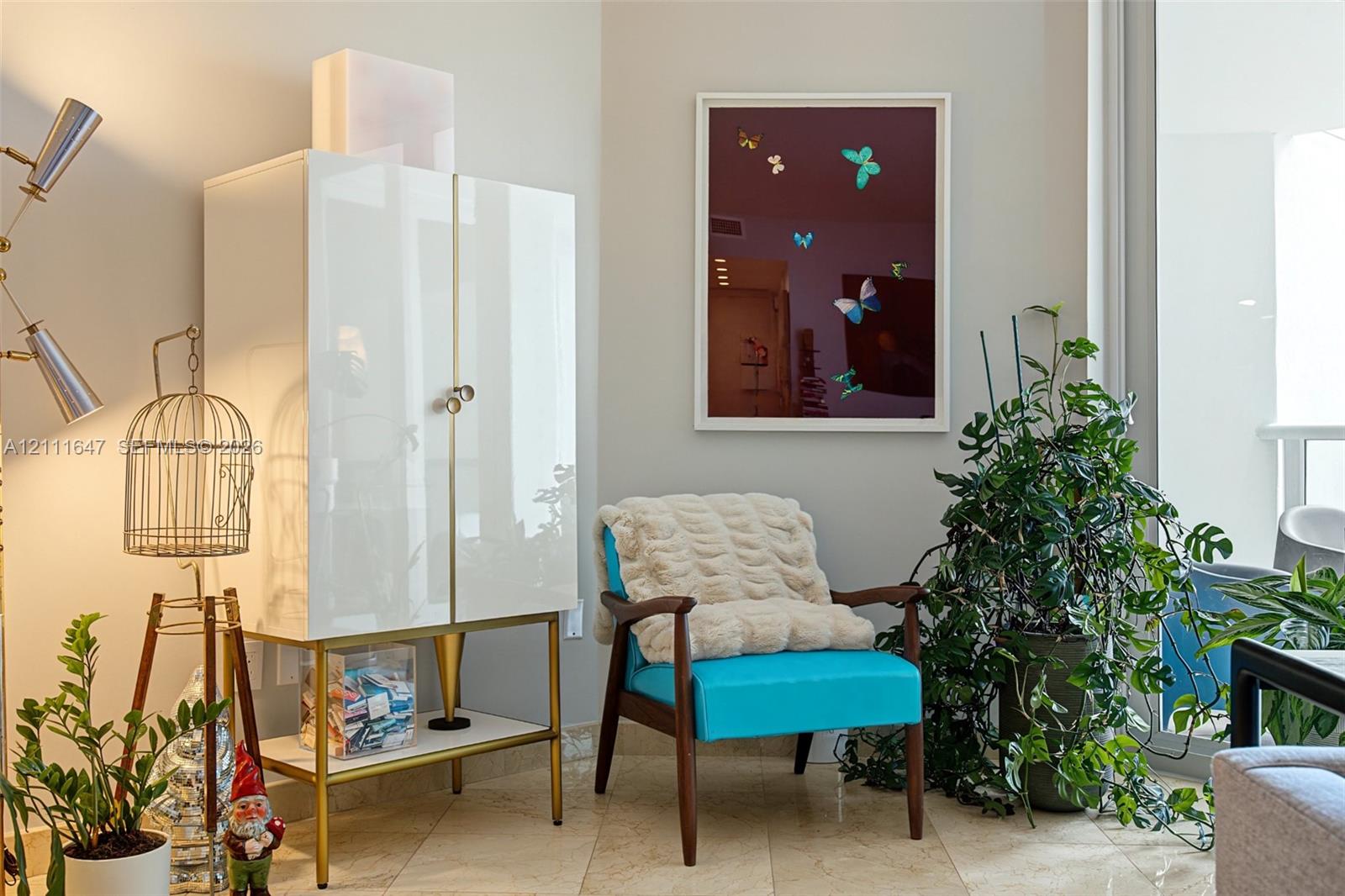Neutral tile flooring and large-format glass door providing natural light