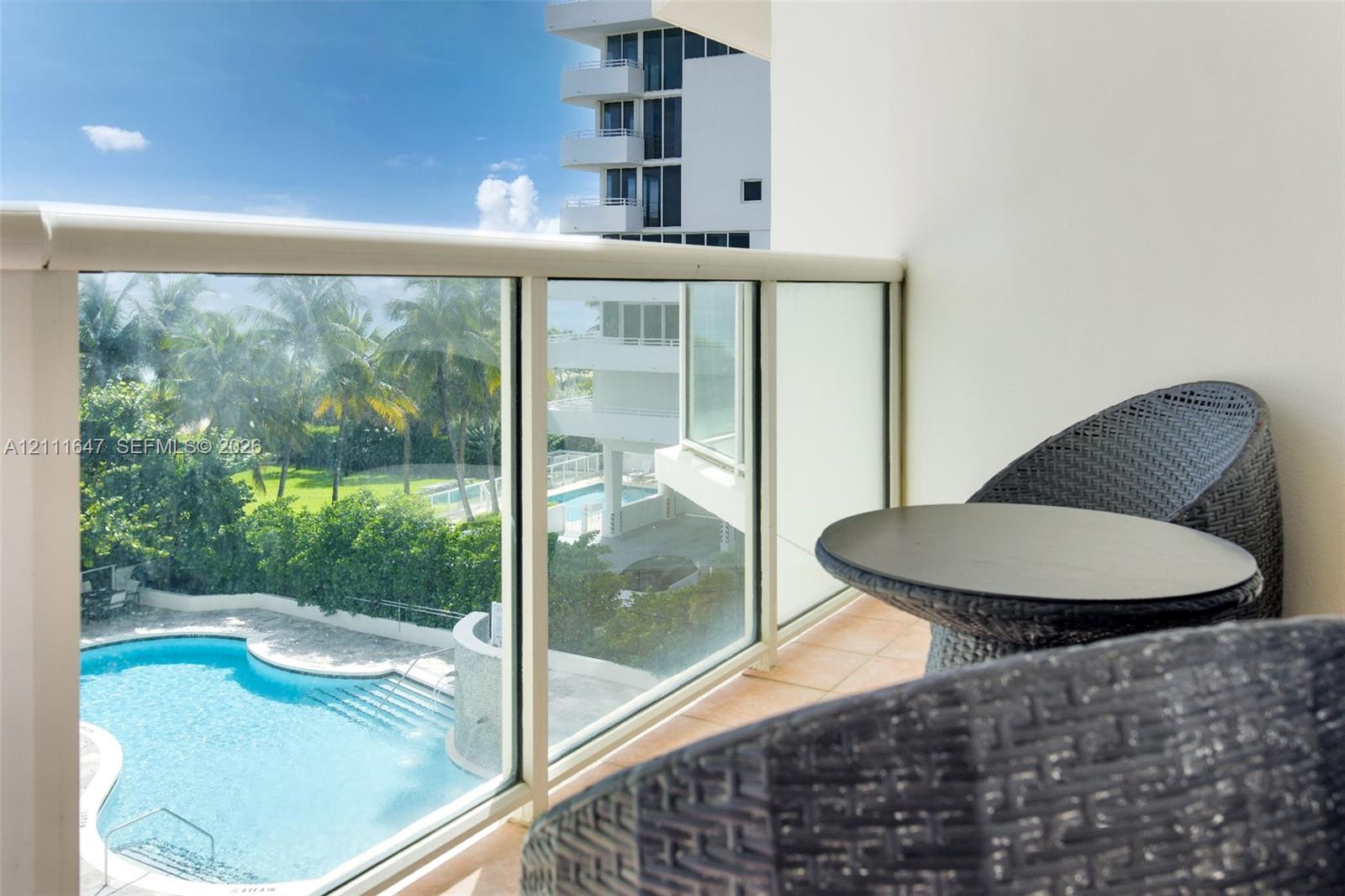 Balcony featuring glass panel railing and tile flooring