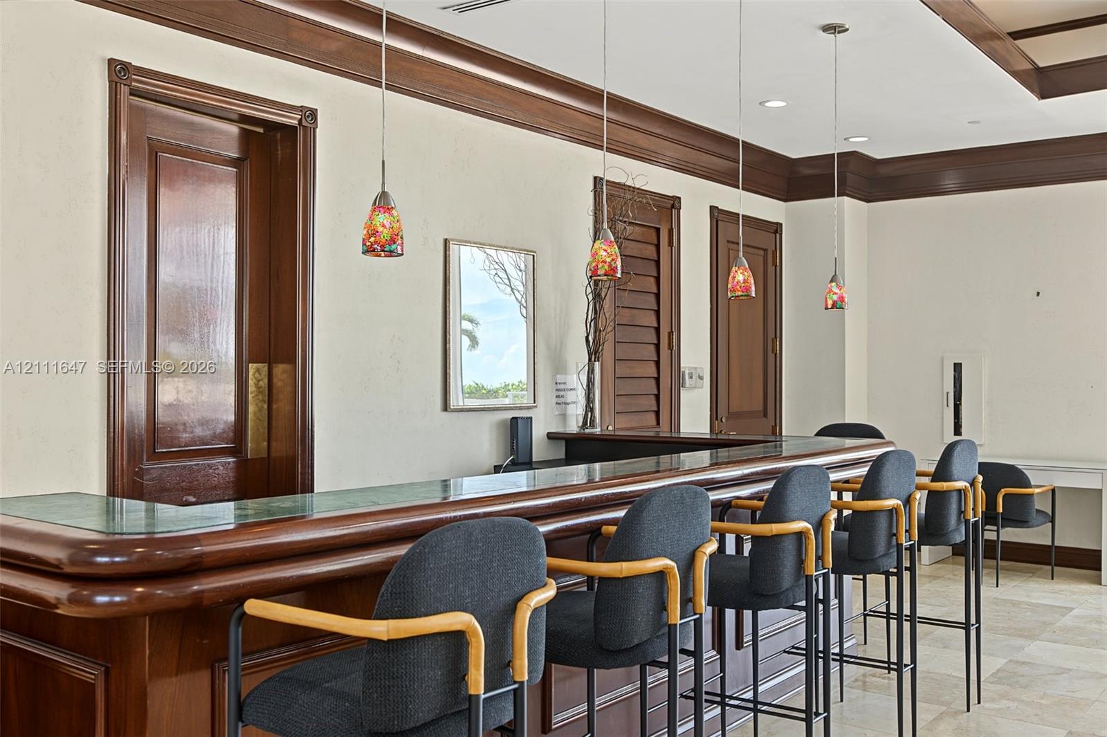 Built-in wooden bar with stone countertop, crown molding, paneled doors, recessed lighting, and stone flooring