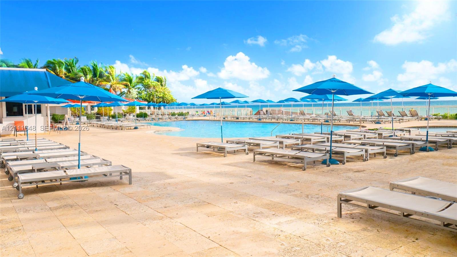 Swimming pool with natural stone decking, perimeter edge design, and expansive ocean backdrop