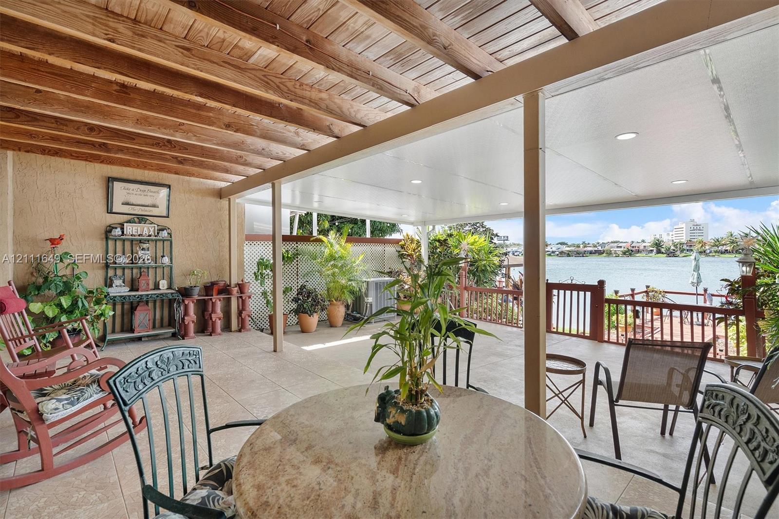 Covered patio featuring a wood-plank ceiling, recessed lighting, tile flooring, and a decorative wood railing Covered patio featuring a wood-plank ceiling, recessed lighting, tile flooring, and a decorative wood railing