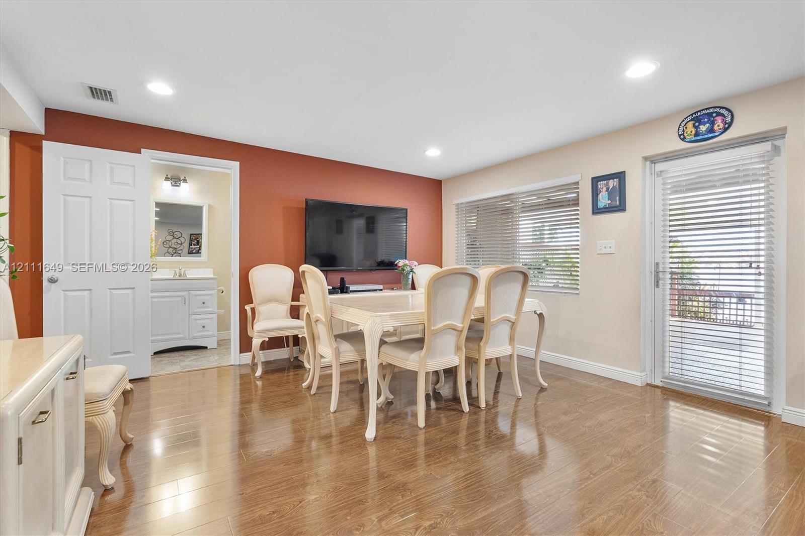 Wood-finish flooring, recessed lighting, accent wall, and glass-paneled exterior door