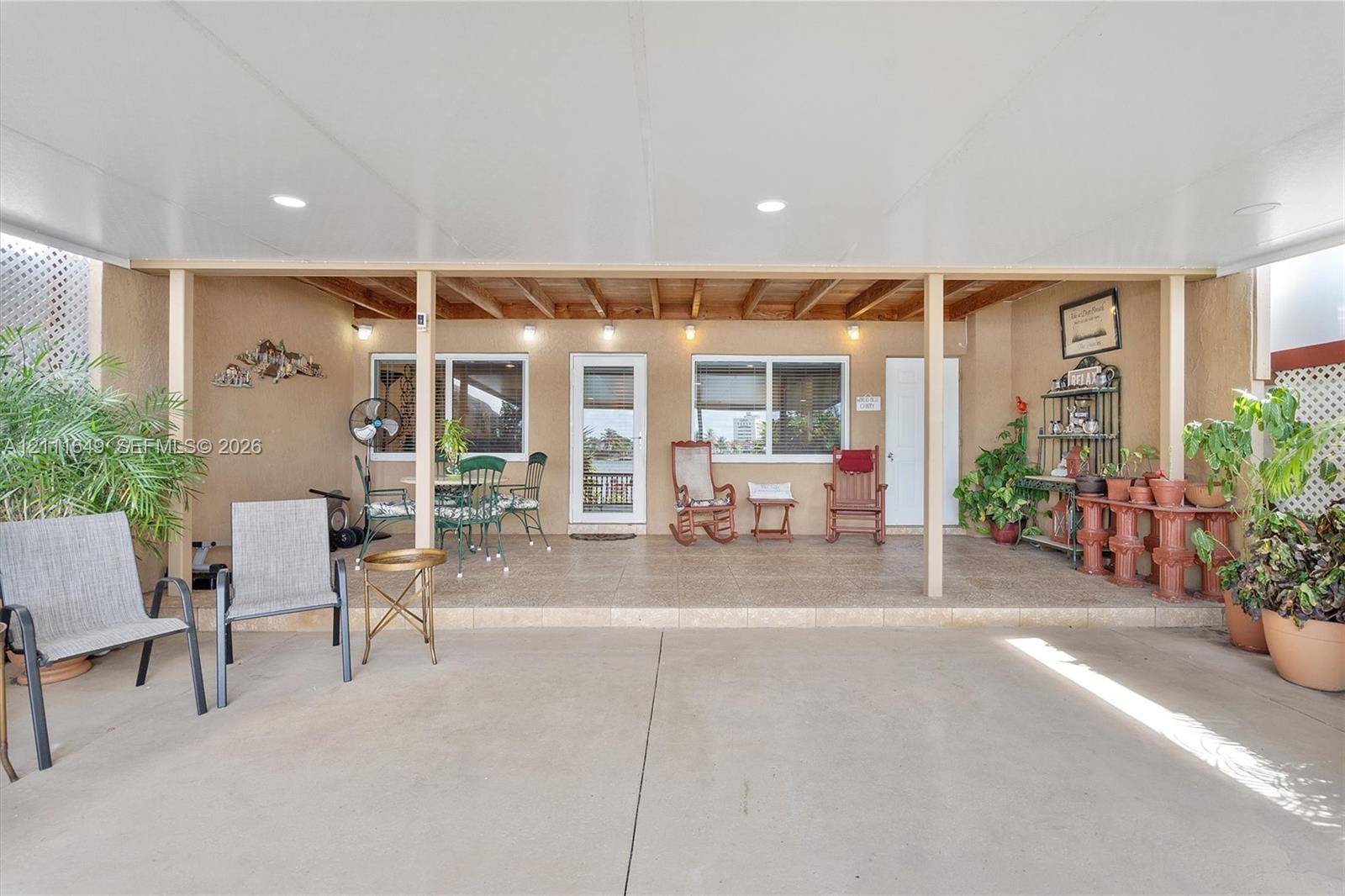 Covered patio featuring recessed lighting, a concrete floor, and tile surfacing Covered patio featuring recessed lighting, a concrete floor, and tile surfacing