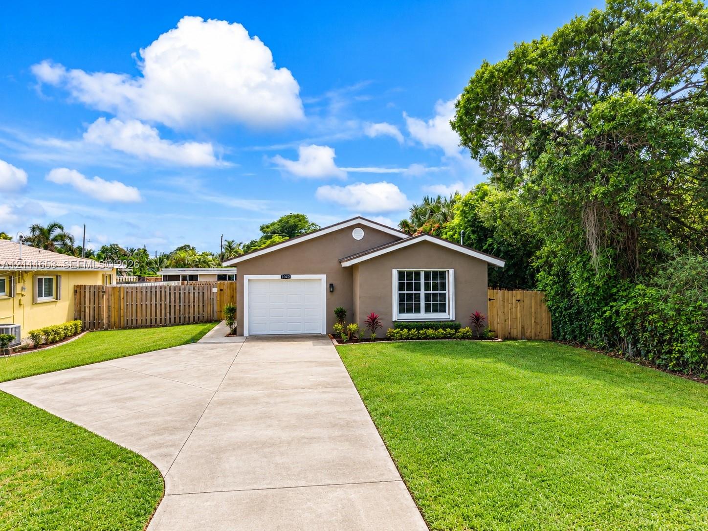Single-story residence featuring a concrete driveway, attached one-car garage, and wooden privacy fencing Single-story residence featuring a concrete driveway, attached one-car garage, and wooden privacy fencing