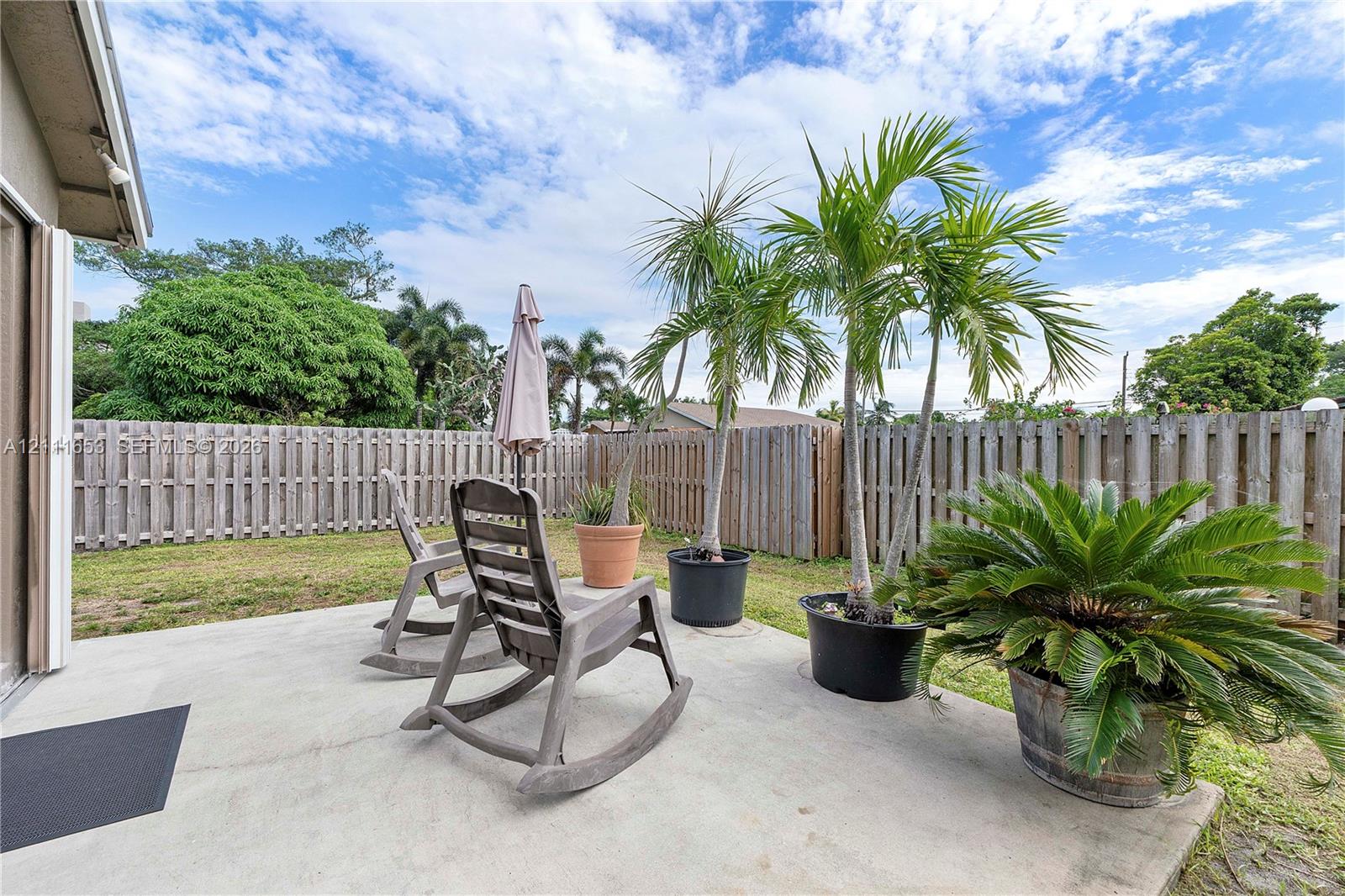 Concrete patio space enclosed by wood privacy fencing
