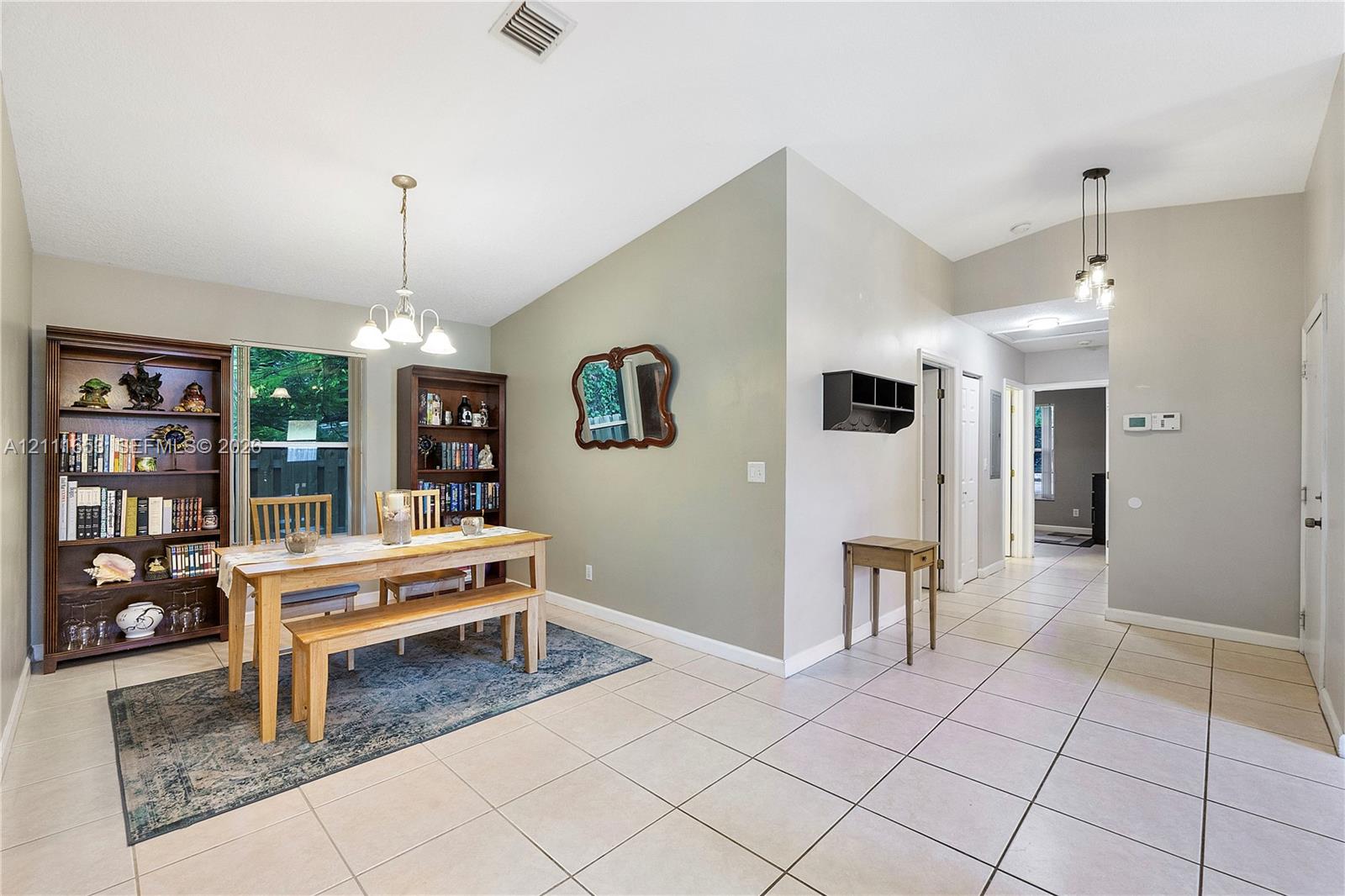 Formal Dining with vaulted ceilings, large-format tile flooring, and multi-light pendant fixtures Formal Dining with vaulted ceilings, large-format tile flooring, and multi-light pendant fixtures