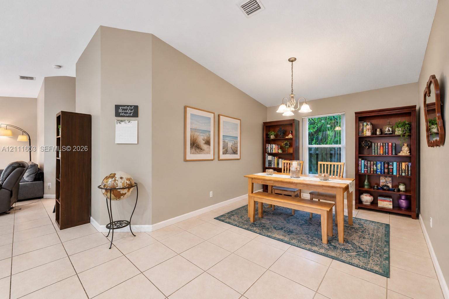 Neutral-toned interior featuring ceramic tile flooring, vaulted ceilings, and a decorative multi-arm chandelier Neutral-toned interior featuring ceramic tile flooring, vaulted ceilings, and a decorative multi-arm chandelier