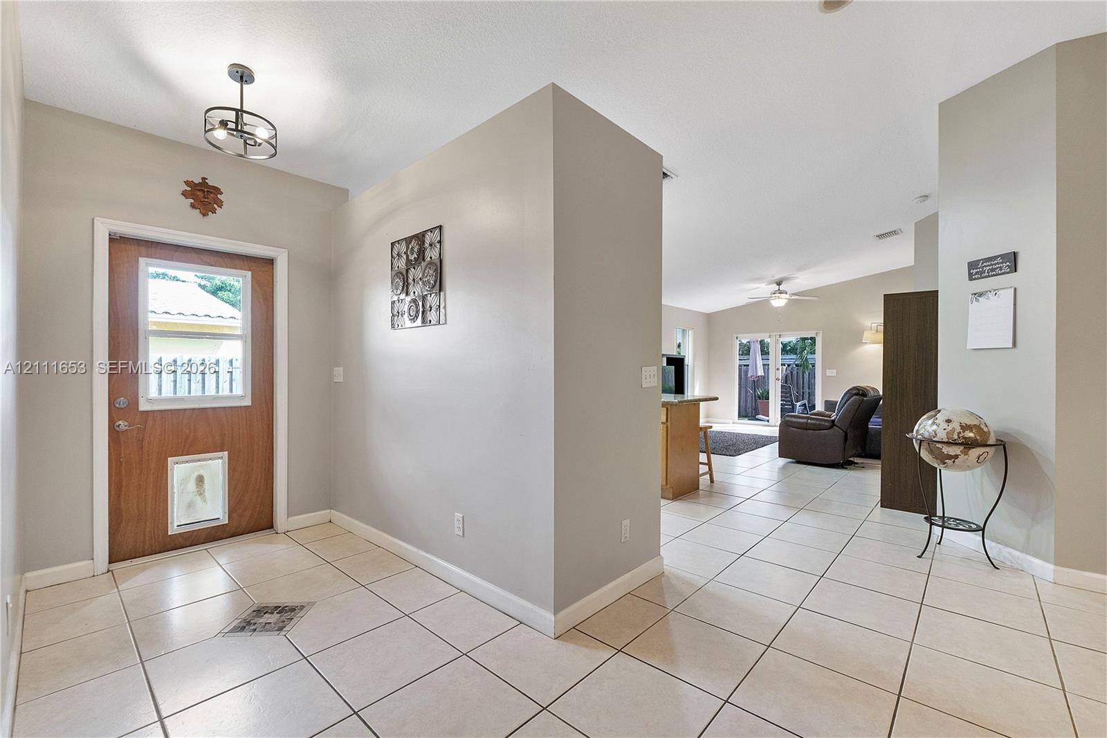 Entryway featuring tile flooring, neutral wall paint, and a wood-finish exterior door with a glass inset