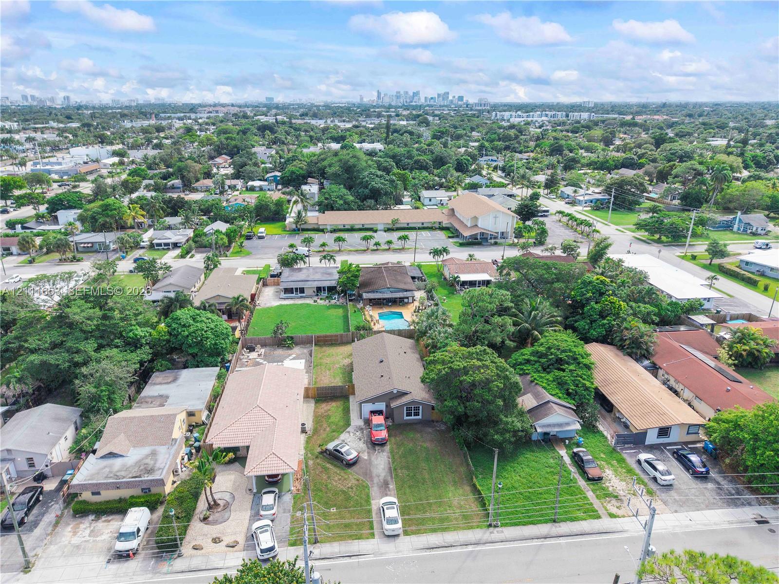 Aerial perspective featuring expansive residential lots with mature trees, established landscaping, and paved driveways