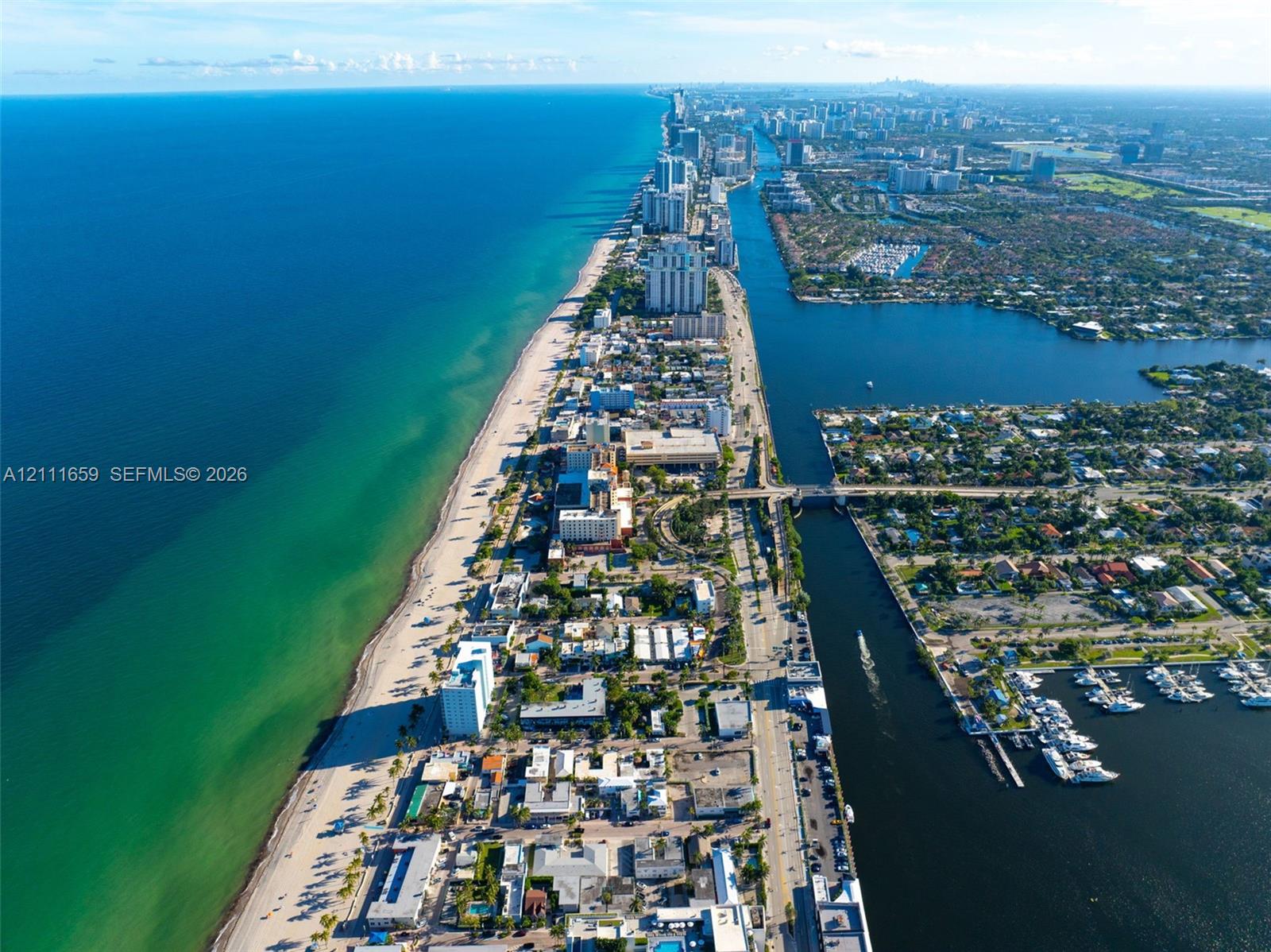 Aerial perspective of the coastline featuring expansive ocean frontage, sandy beaches, inland waterway access, and harbor docking facilities