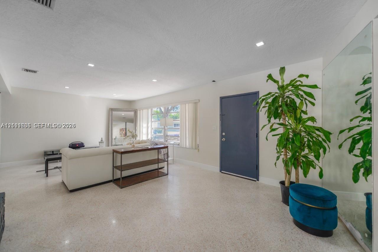 Interior space featuring polished terrazzo flooring, recessed lighting, and a large wall-mounted mirror panel