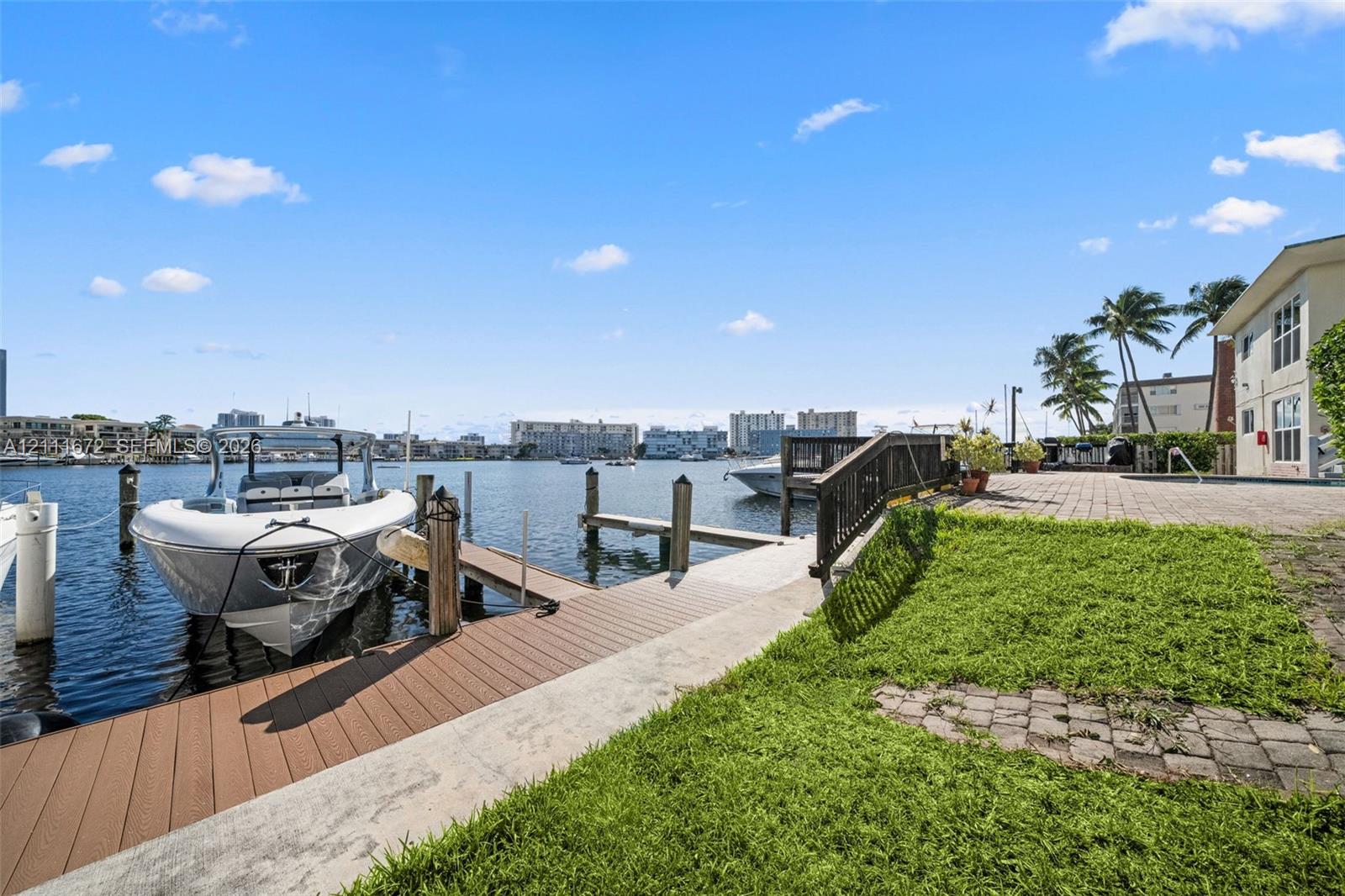 Waterfront property featuring a private boat dock, composite decking, paver patio, and lawn space Waterfront property featuring a private boat dock, composite decking, paver patio, and lawn space