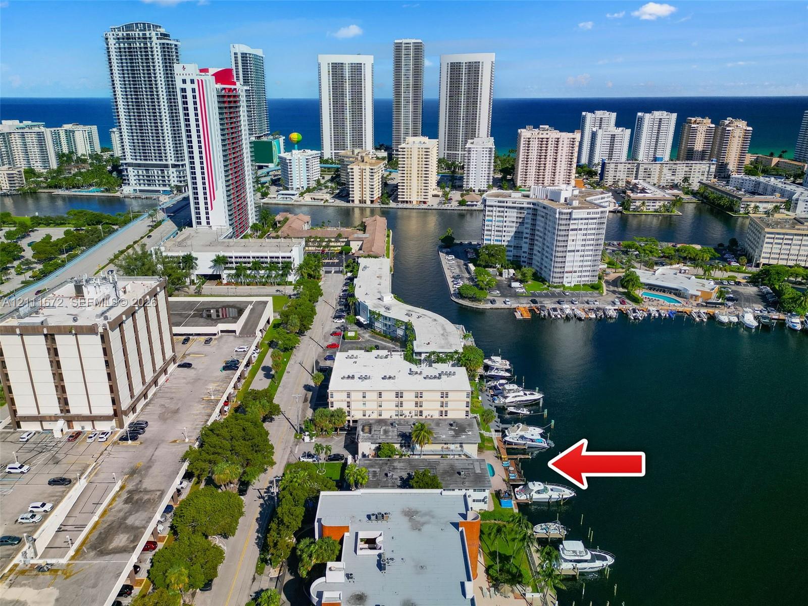 Aerial perspective of waterfront property featuring deep-water dockage, direct waterway access, and paved exterior grounds