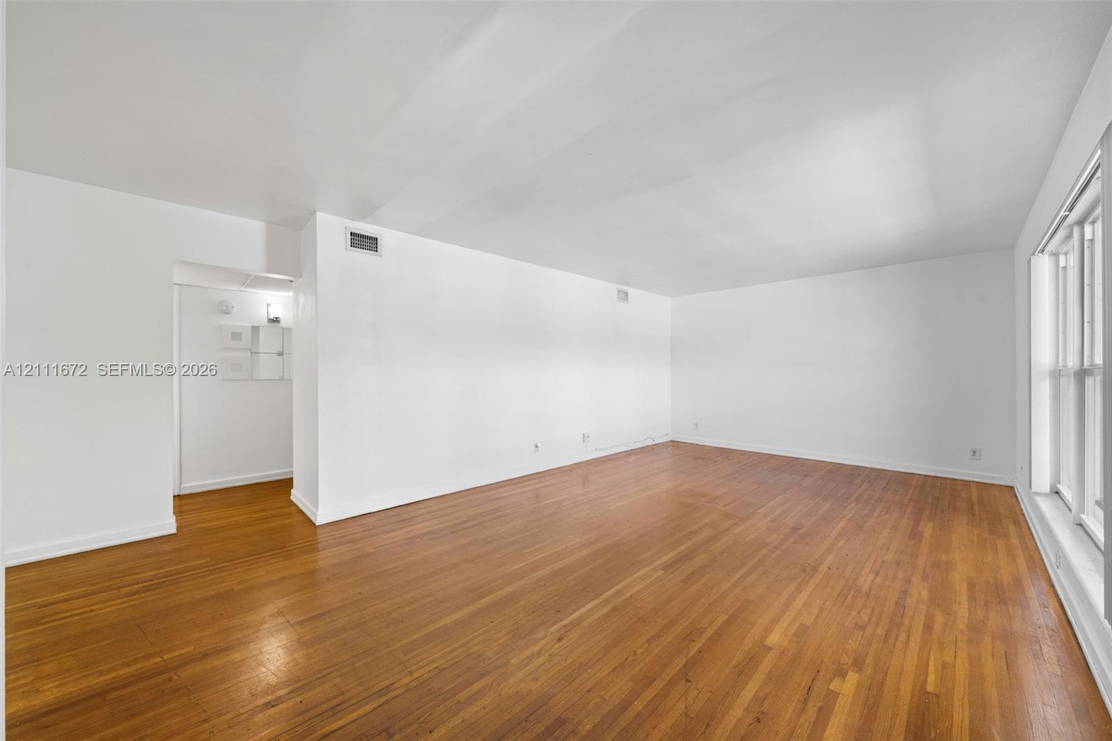 Open living space featuring wood-finish flooring and large windows