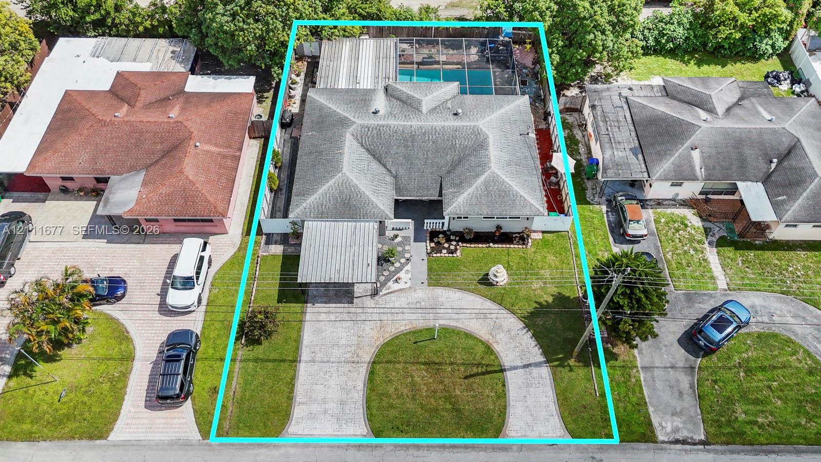 Aerial perspective of a property featuring a circular paver driveway, a front-facing covered carport, a hip roof, and a screened-in rear pool enclosure Aerial perspective of a property featuring a circular paver driveway, a front-facing covered carport, a hip roof, and a screened-in rear pool enclosure