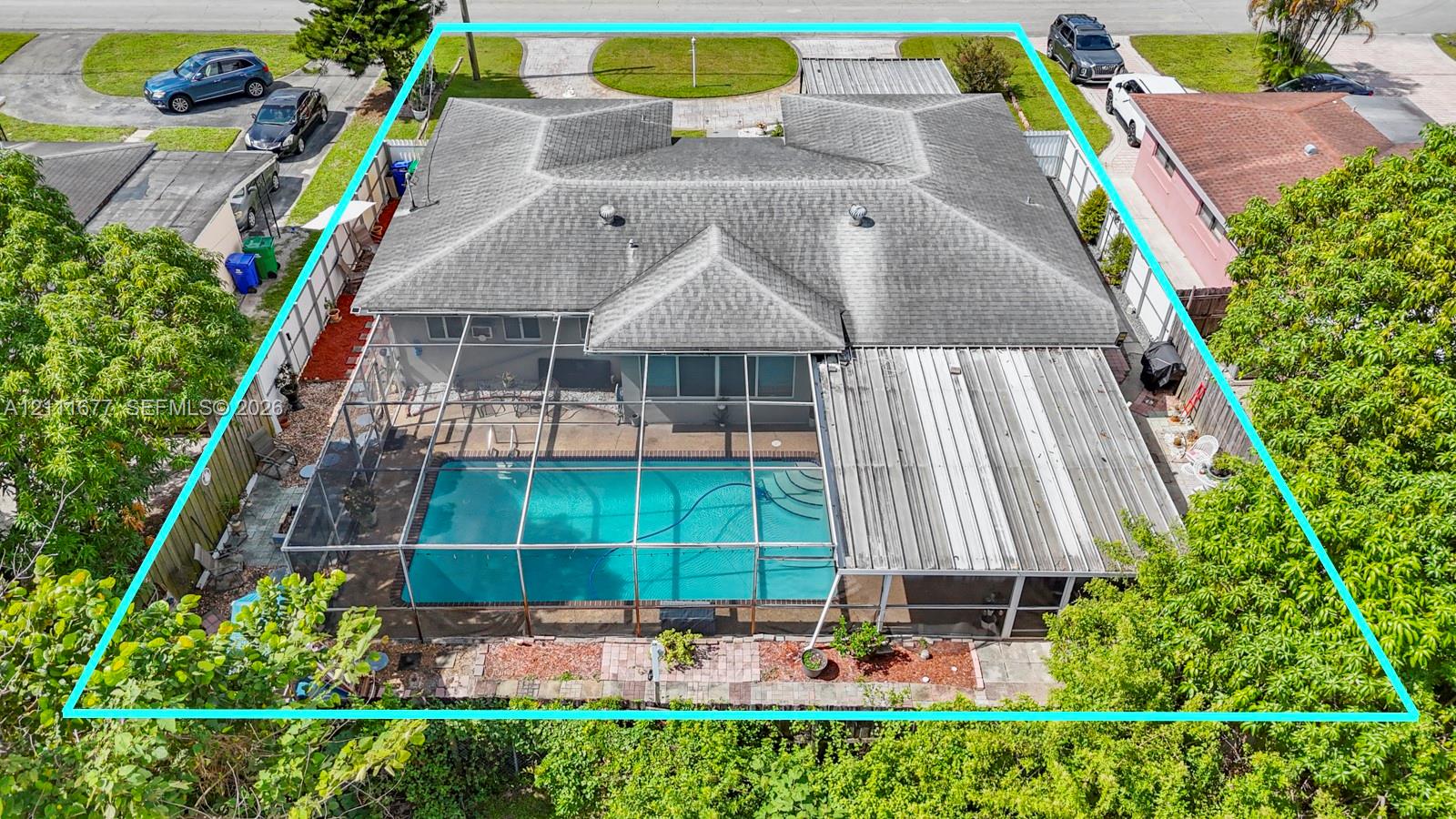 Aerial view of property featuring a screened-in swimming pool, covered patio, fenced perimeter, and shingled roof Aerial view of property featuring a screened-in swimming pool, covered patio, fenced perimeter, and shingled roof