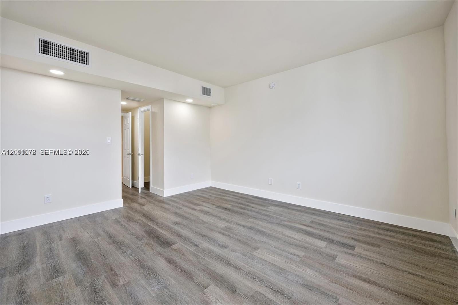Wood-finish flooring, recessed lighting, and neutral wall tones