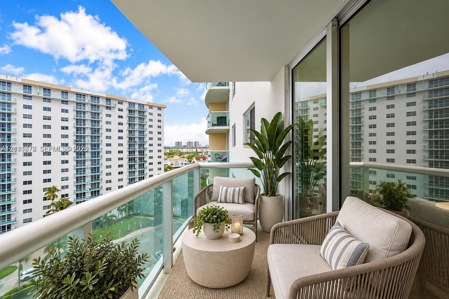 Covered balcony featuring a glass-panel railing, recessed lighting, and expansive sliding glass doors