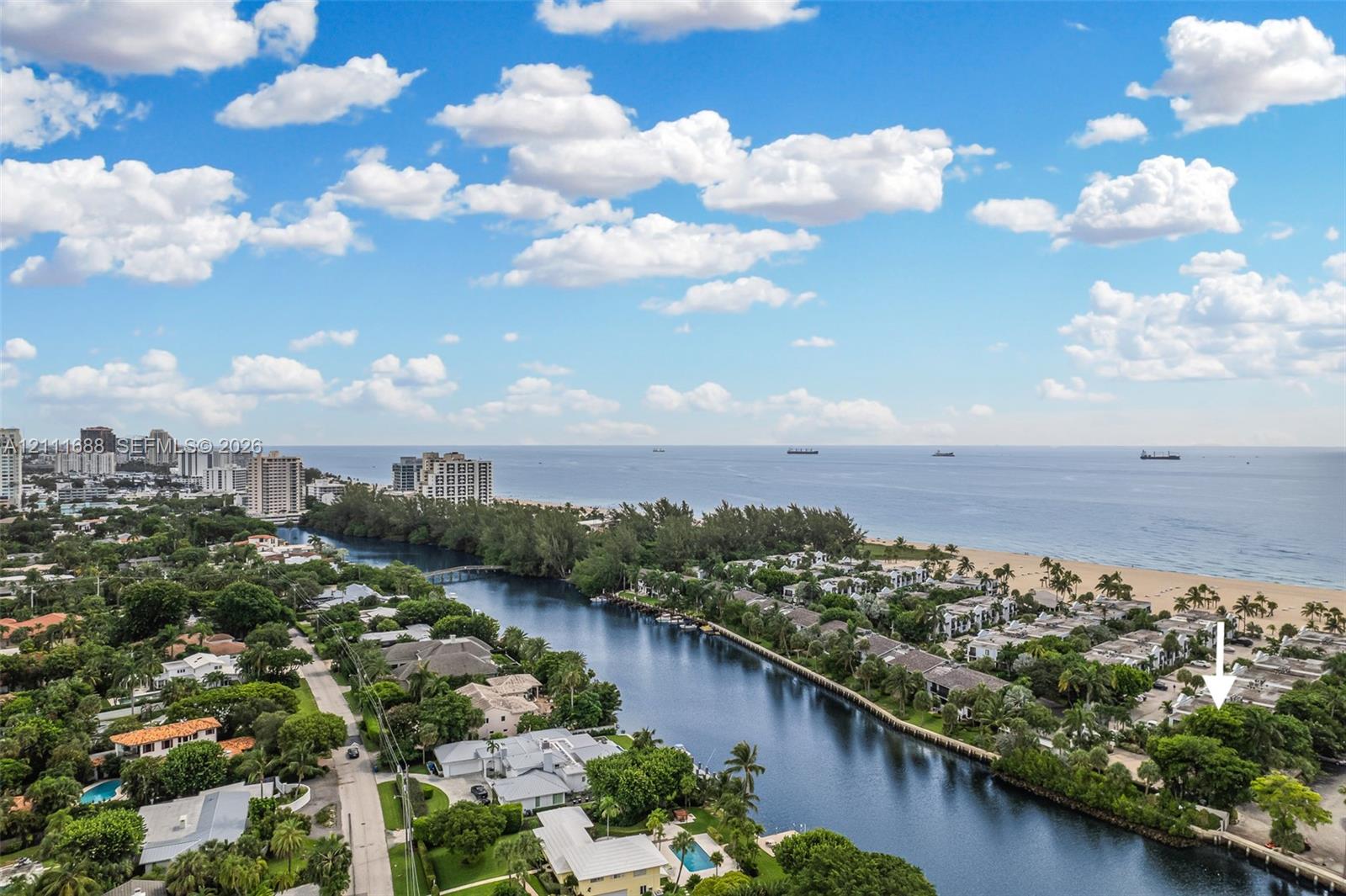 Aerial perspective of coastal property situated on a waterway with proximity to the ocean and sandy coastline