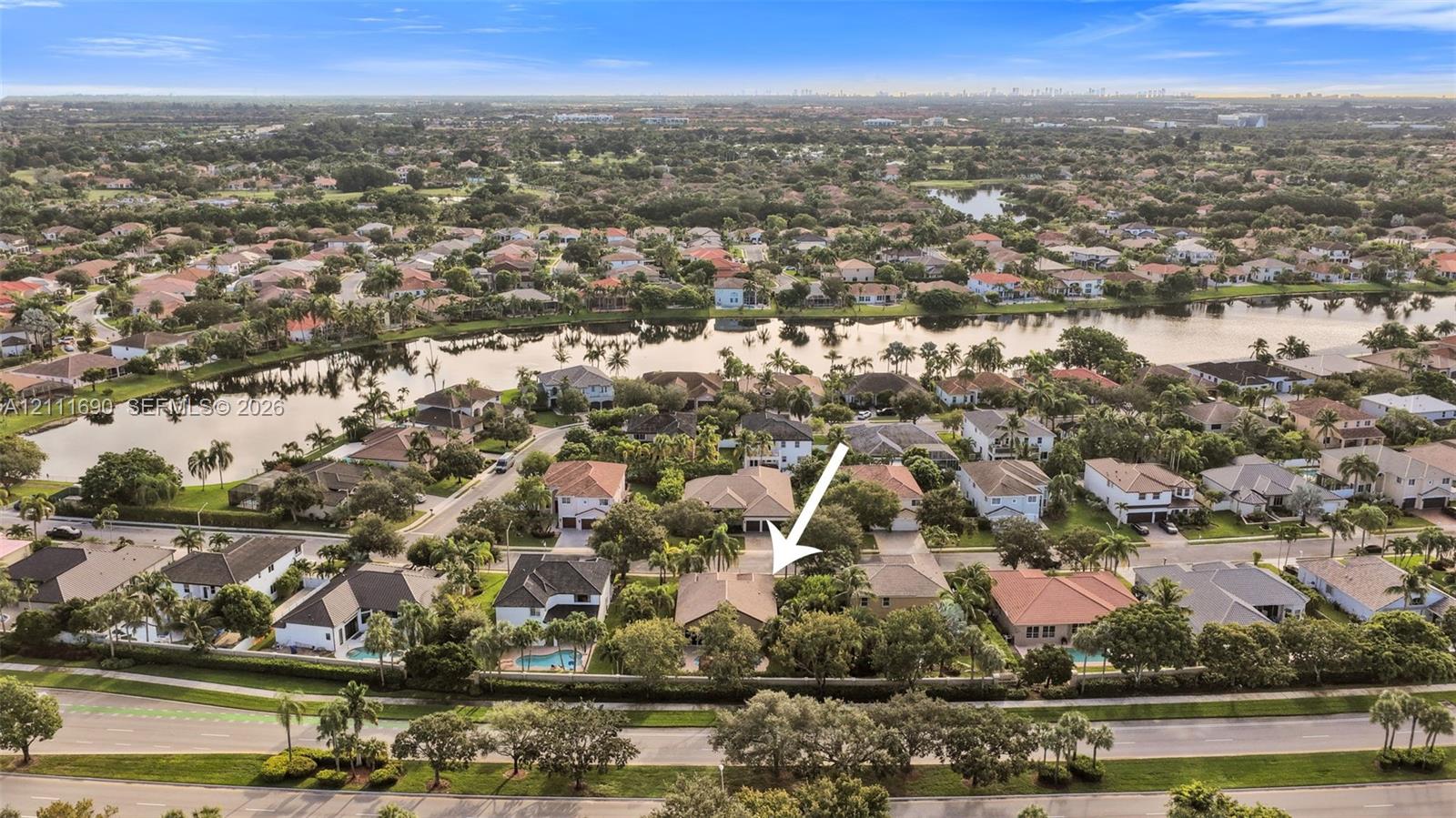 Aerial perspective showcasing a residential property with a tiled roof, mature landscaping, and an expansive backyard