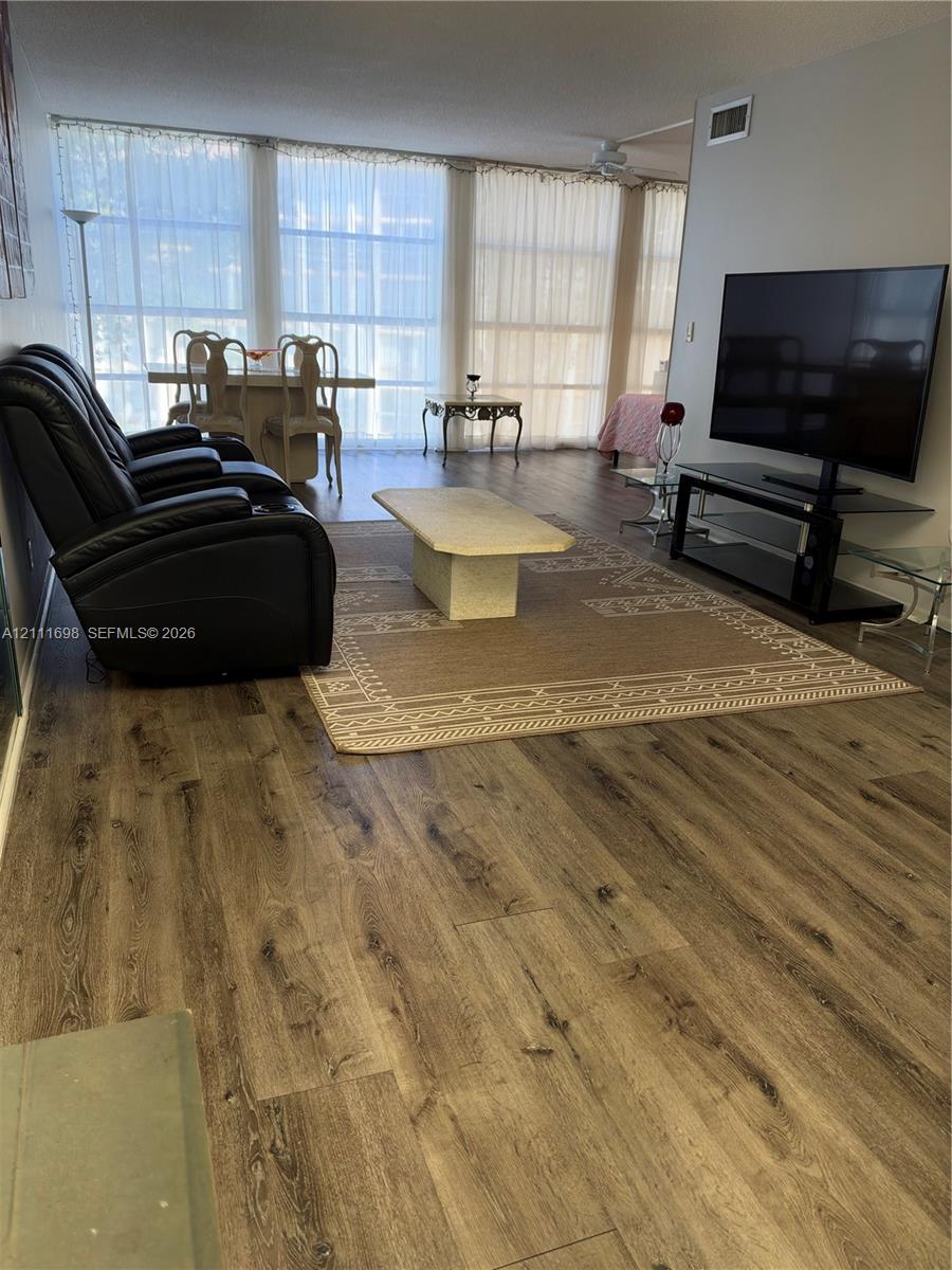 Open living space featuring wood-finish flooring and floor-to-ceiling windows