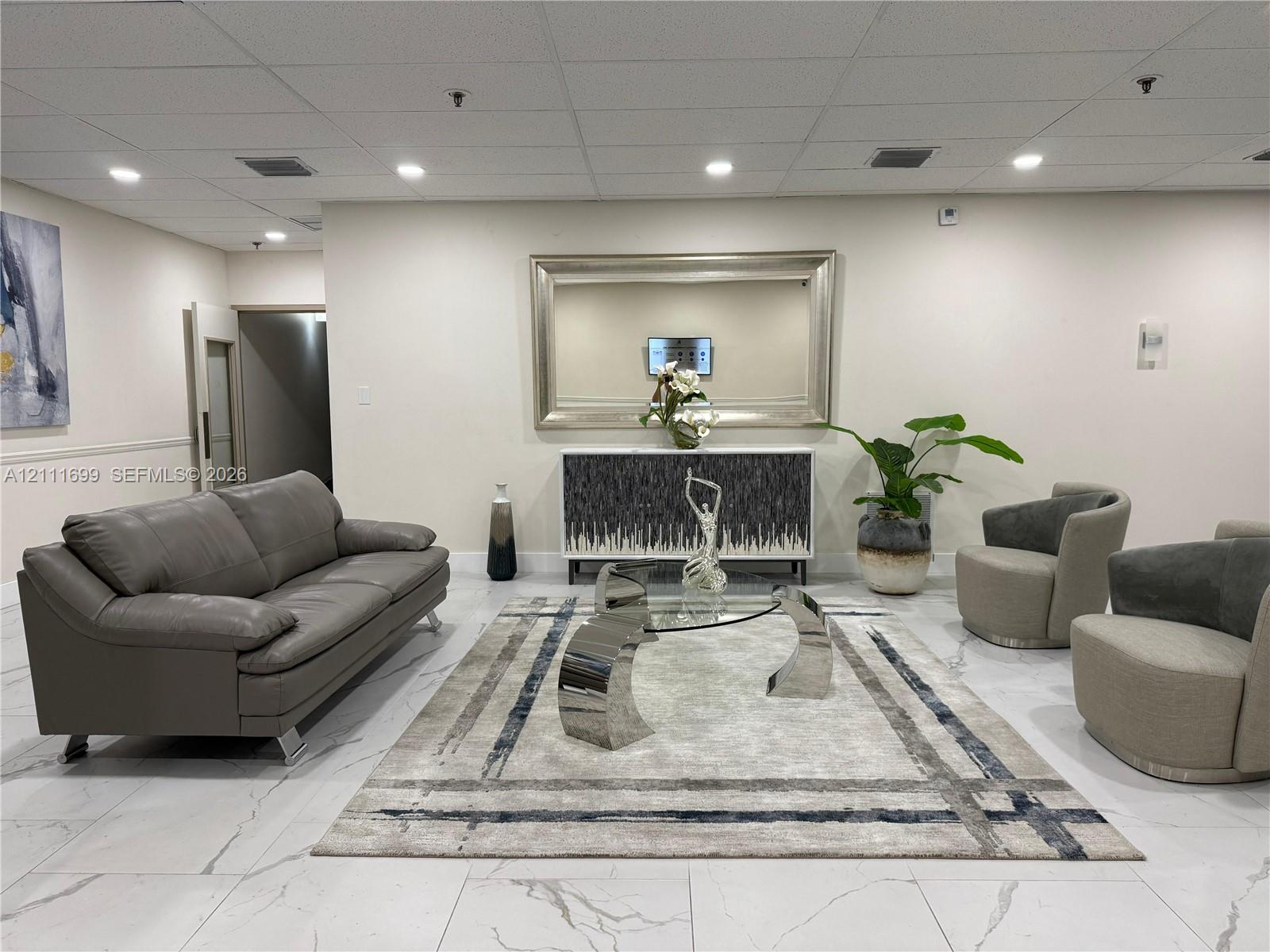Large-format tile flooring with marble-style veining, recessed ceiling lighting, and a neutral wall finish