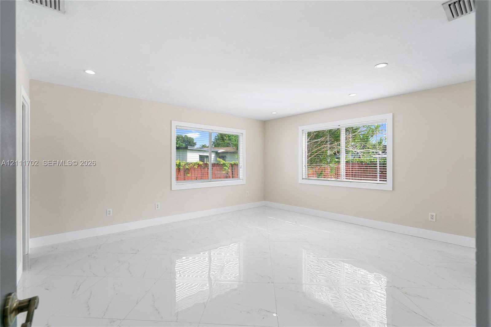 Spacious interior featuring large-format tile flooring, recessed lighting, and expansive windows