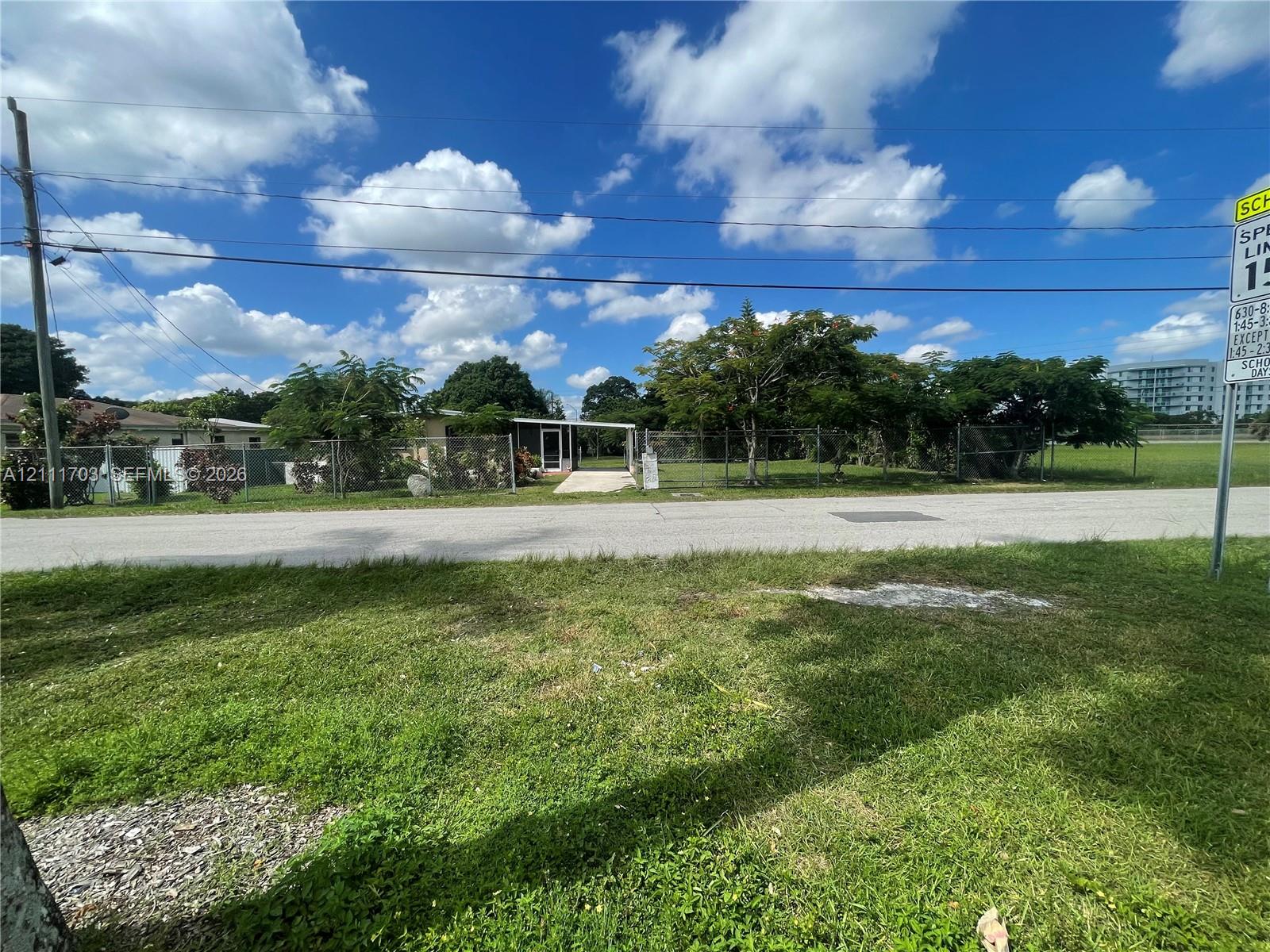 Single-story residence featuring a covered entryway, paved driveway, and chain-link fencing enclosing the property grounds Single-story residence featuring a covered entryway, paved driveway, and chain-link fencing enclosing the property grounds