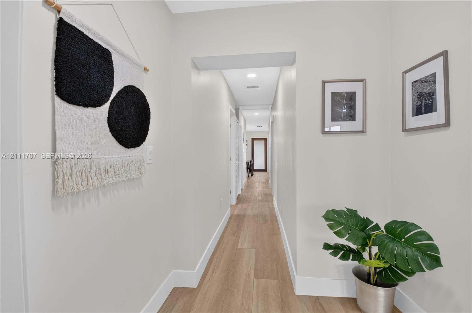 Hallway featuring wood-finish flooring, recessed lighting, and neutral wall tones