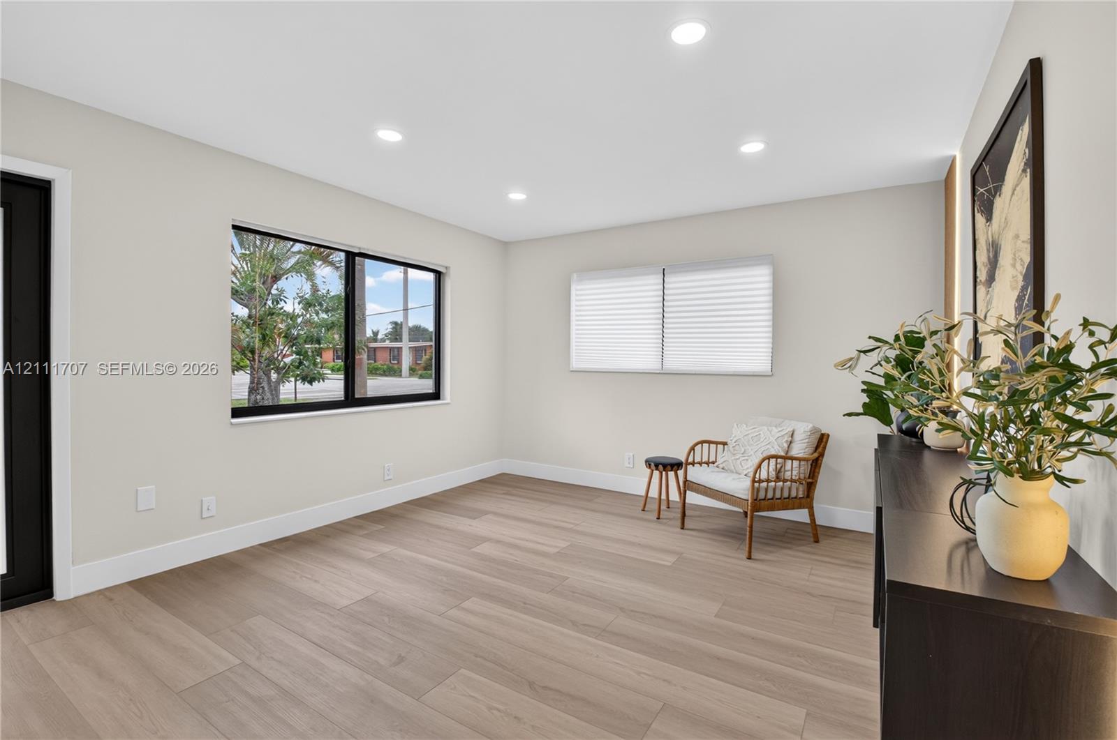 Neutral-toned interior featuring wood-finish flooring, recessed lighting, and black-trimmed windows