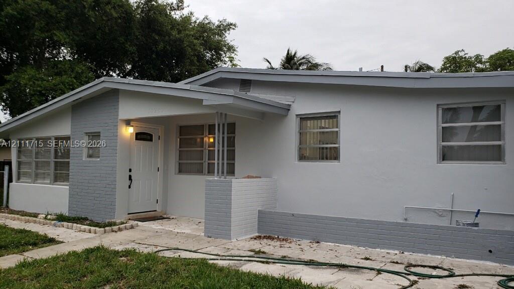 Single-story exterior featuring painted brick accents, horizontal sliding windows, a recessed entryway, and a covered porch Single-story exterior featuring painted brick accents, horizontal sliding windows, a recessed entryway, and a covered porch
