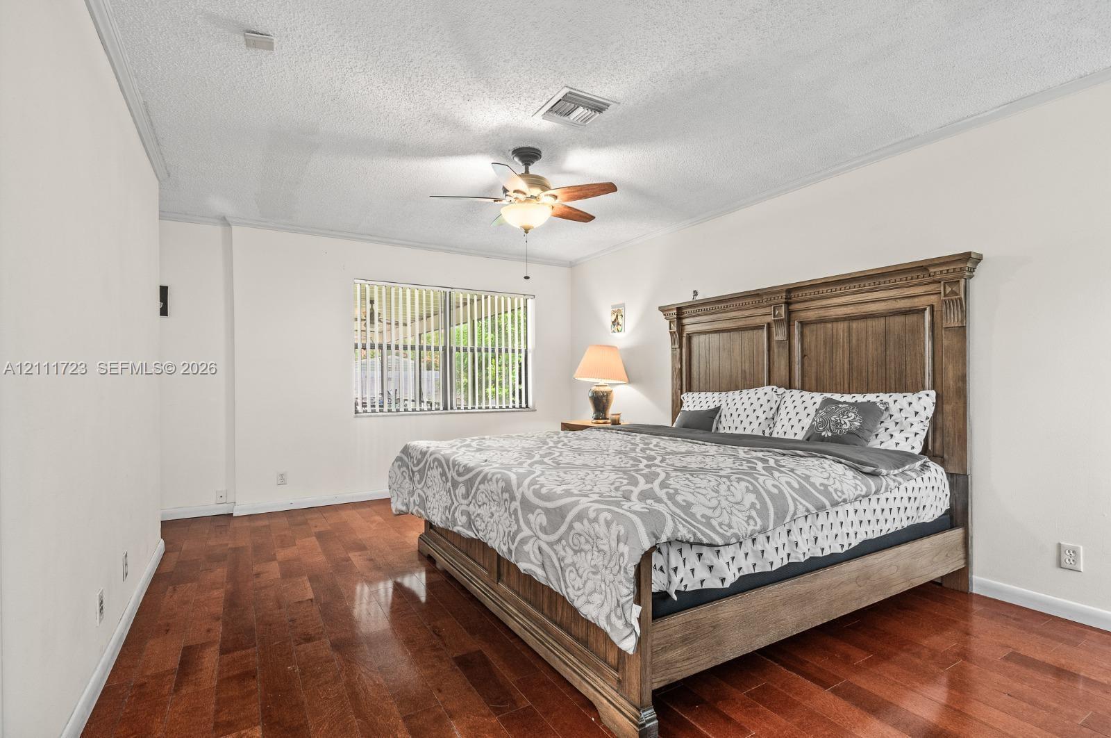 Interior space featuring wood-finish flooring, a ceiling fan with integrated light fixture, and horizontal window blinds